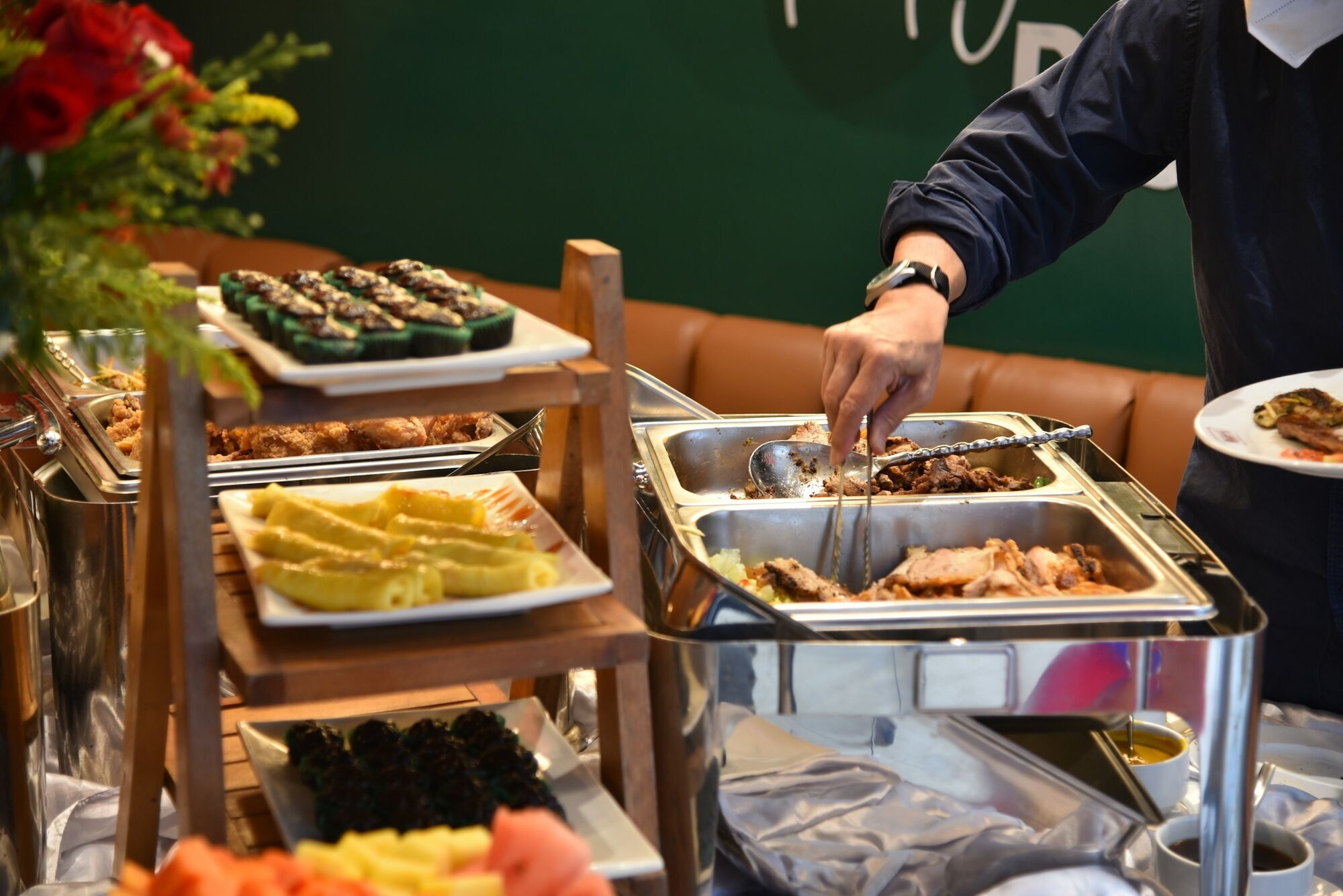 Cruise buffet with hot food trays and a passenger serving food