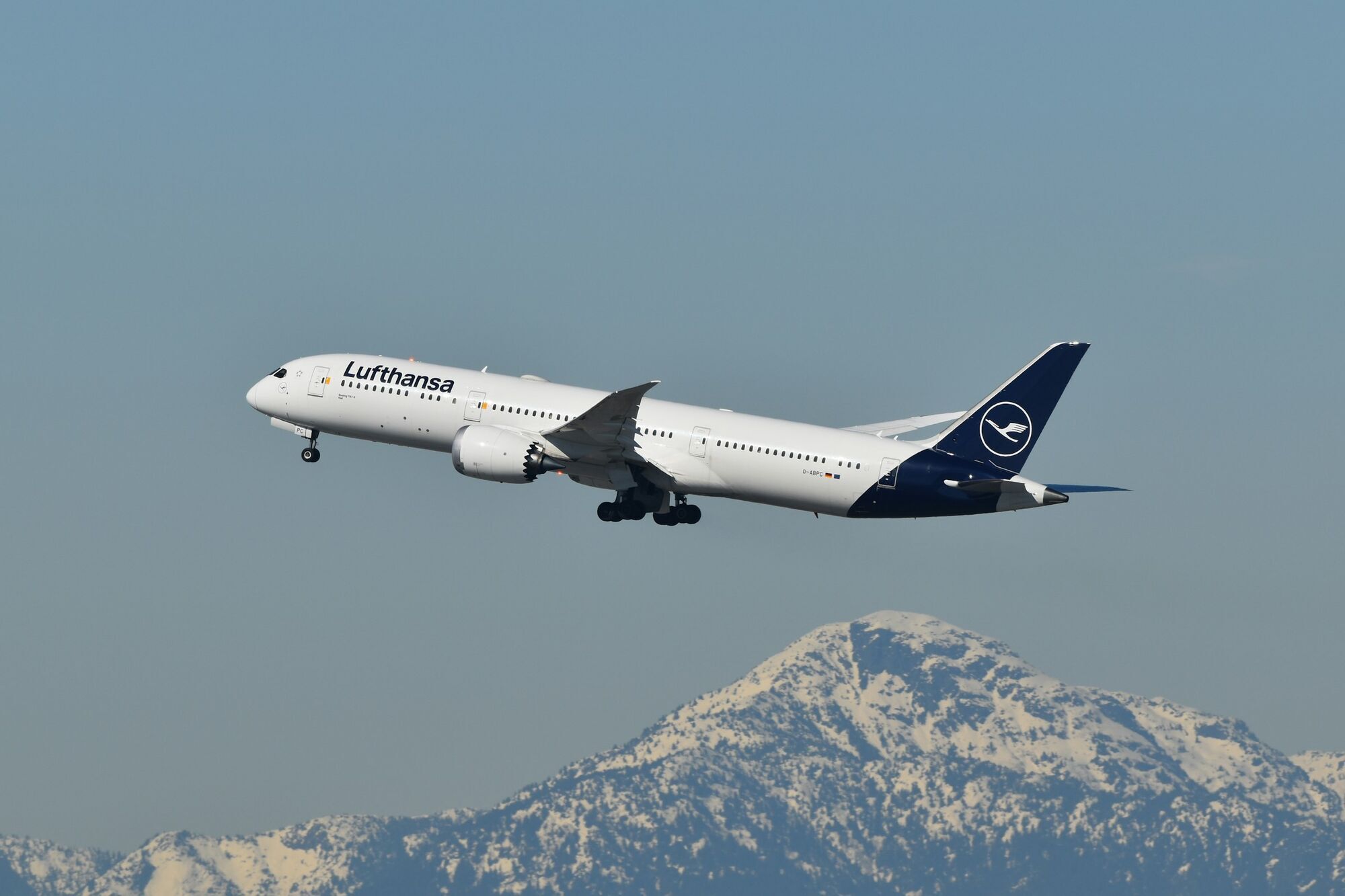 Lufthansa aircraft flying above snowy mountains