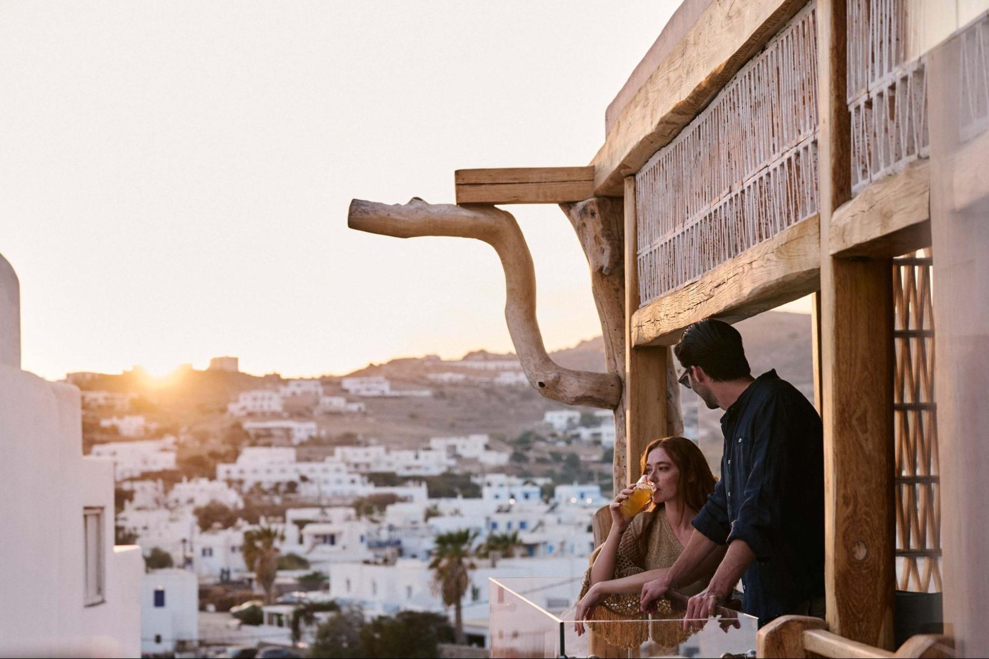 Guests on a Mykonos terrace at sunset