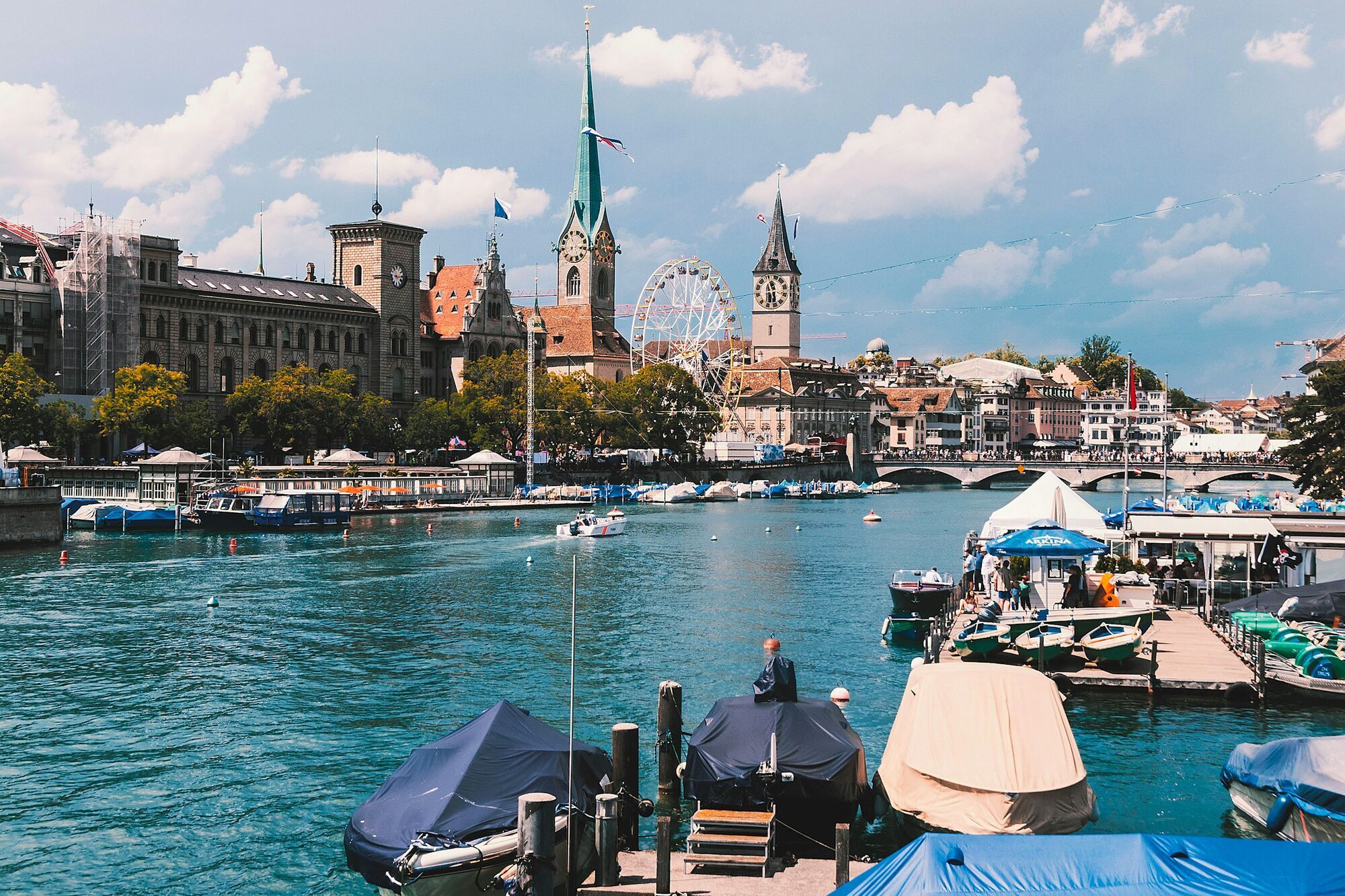 Boats along Zurich waterfront with historic buildings and bridges
