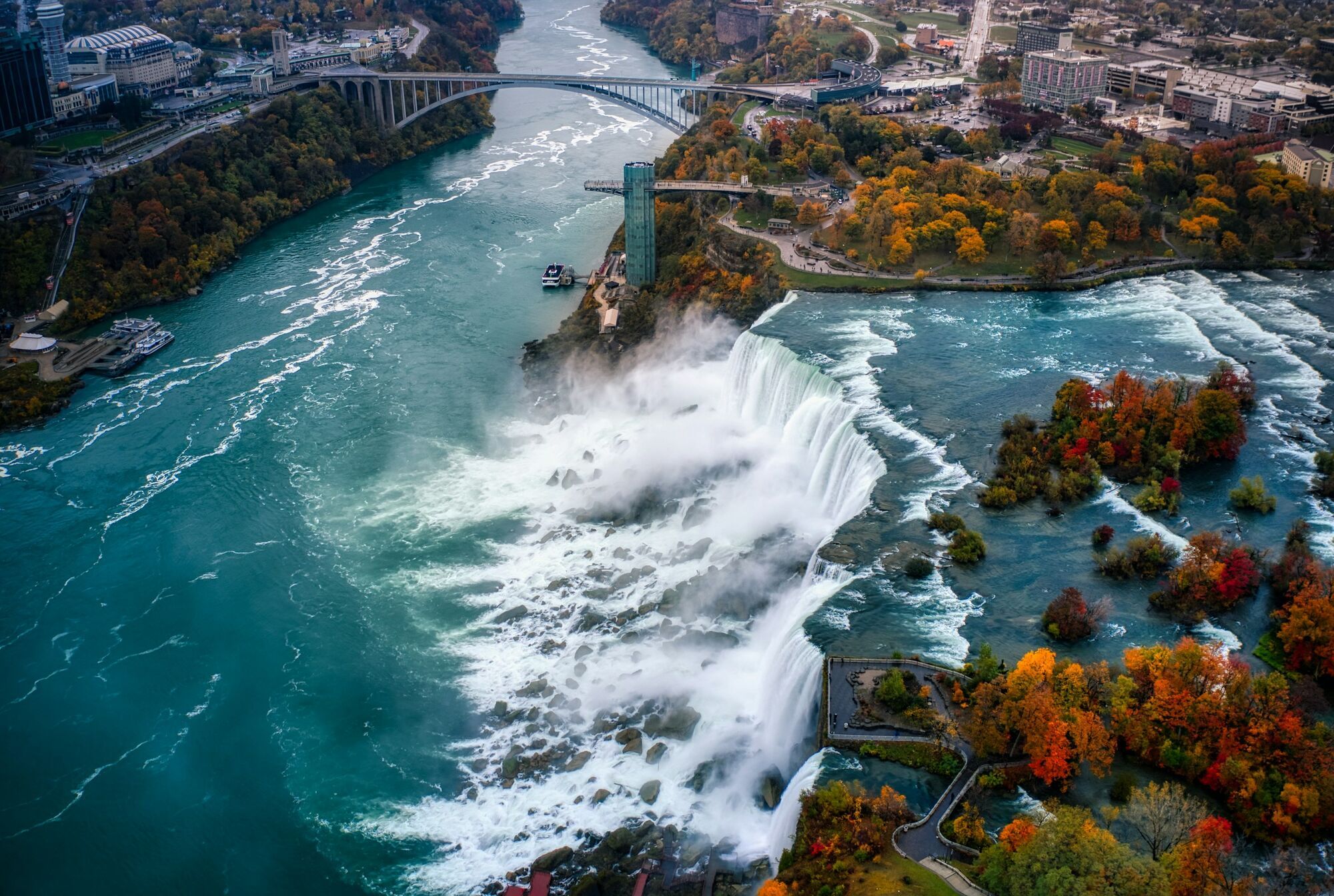 Aerial view of Niagara Falls with mist rising and surrounding autumn landscape