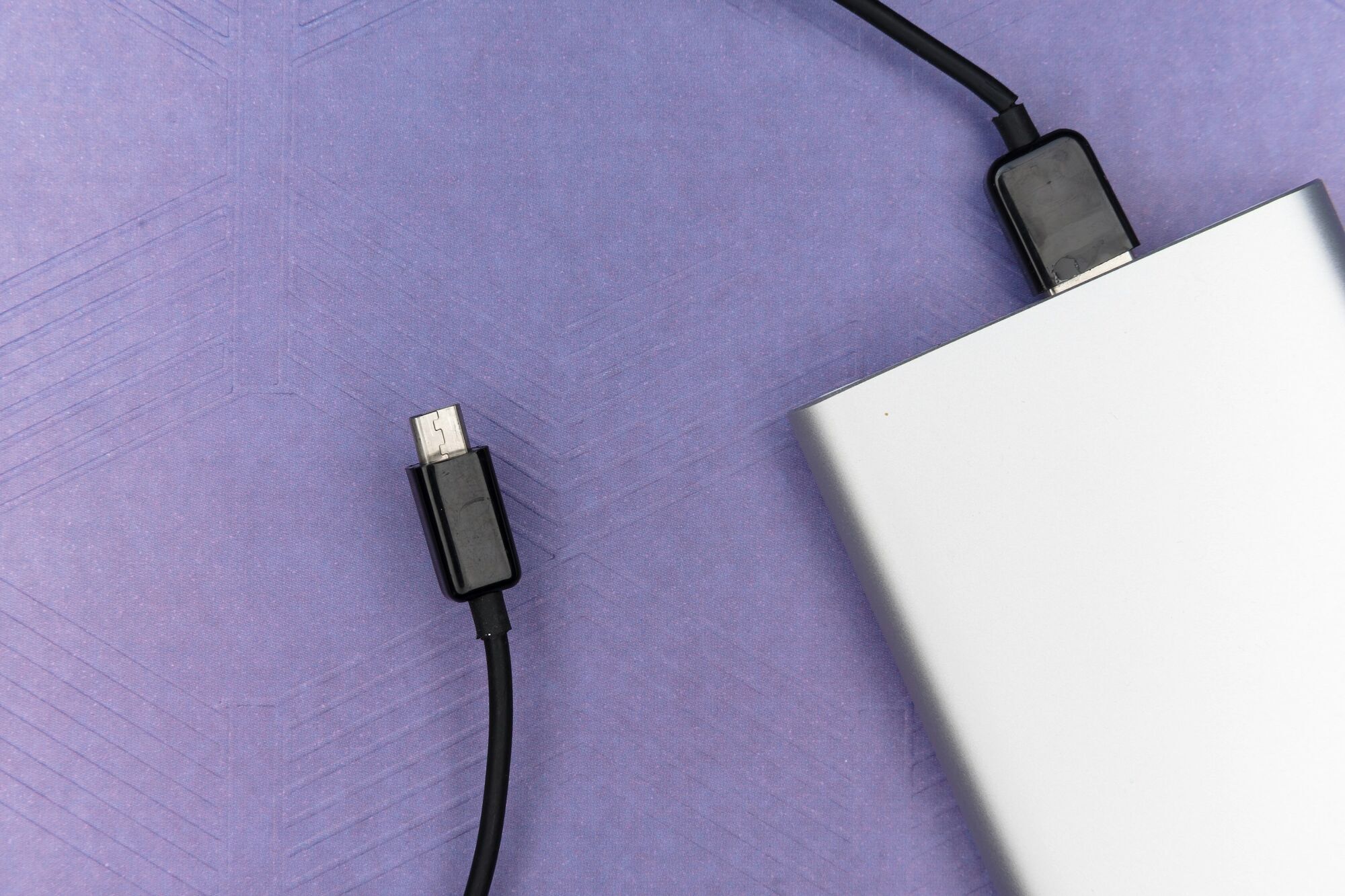Power bank with charging cable on a purple background