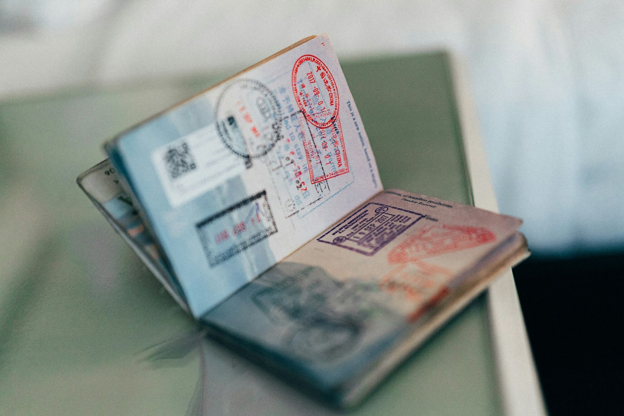 Open passport with travel stamps lying on a table