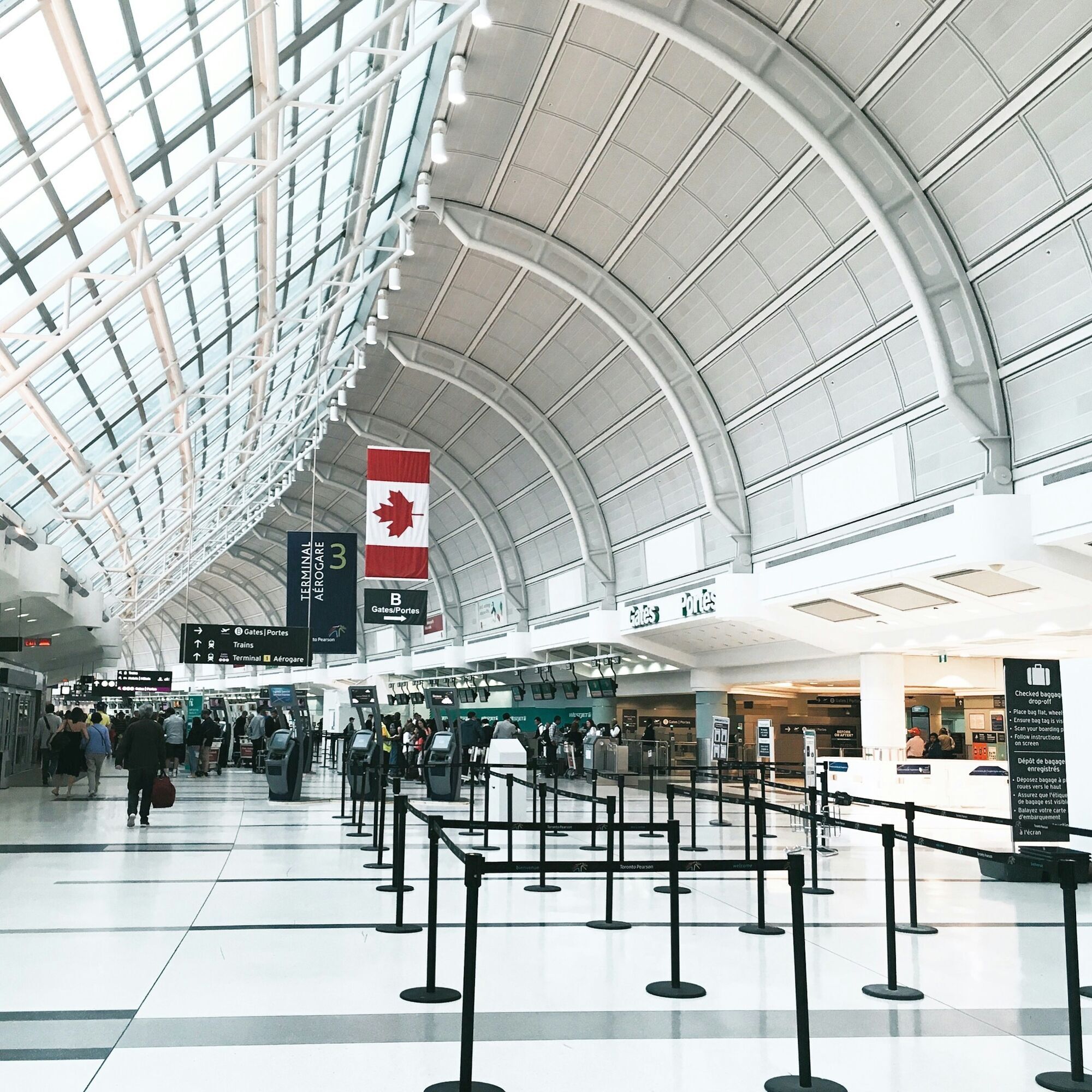 Check-in area inside Toronto Pearson Airport with Canadian flag