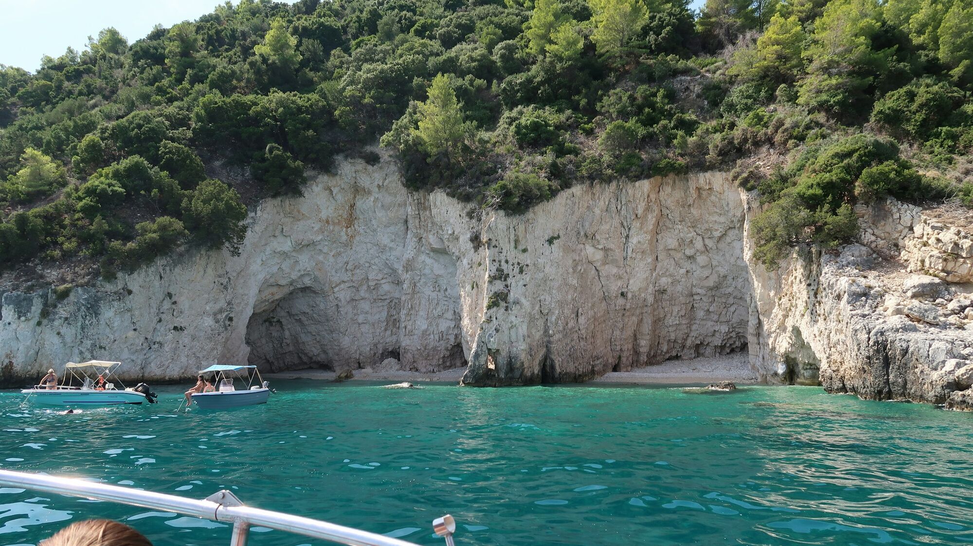 Boats near rocky cliffs and turquoise water in Zante