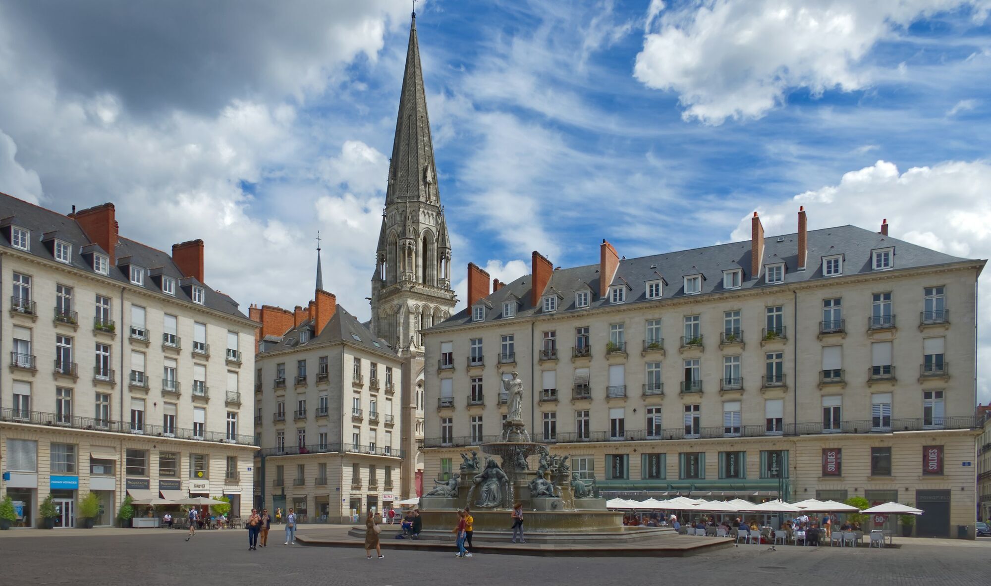 Historic square in Nantes with a cathedral tower and fountain