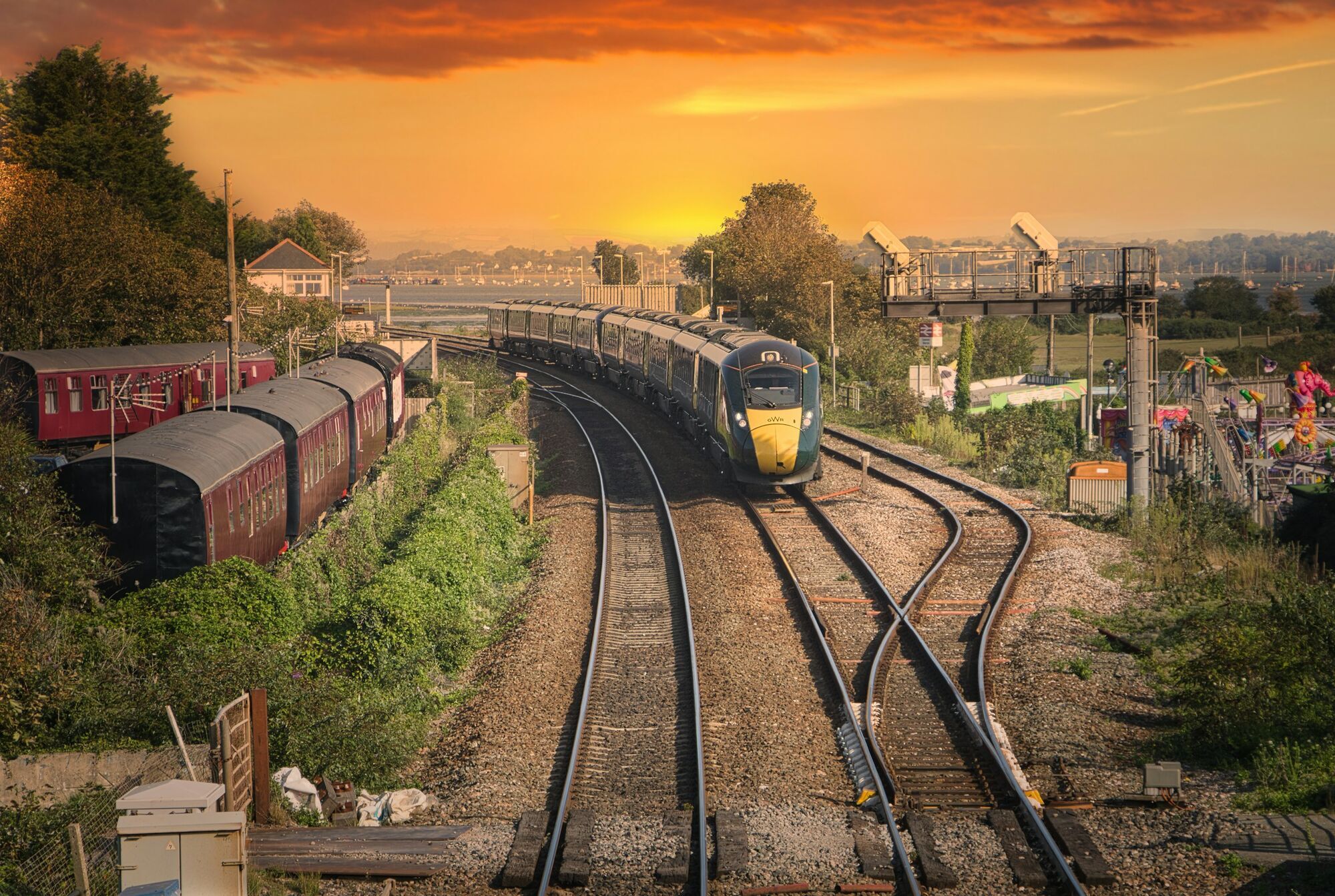 GWR train travelling on railway tracks at sunset