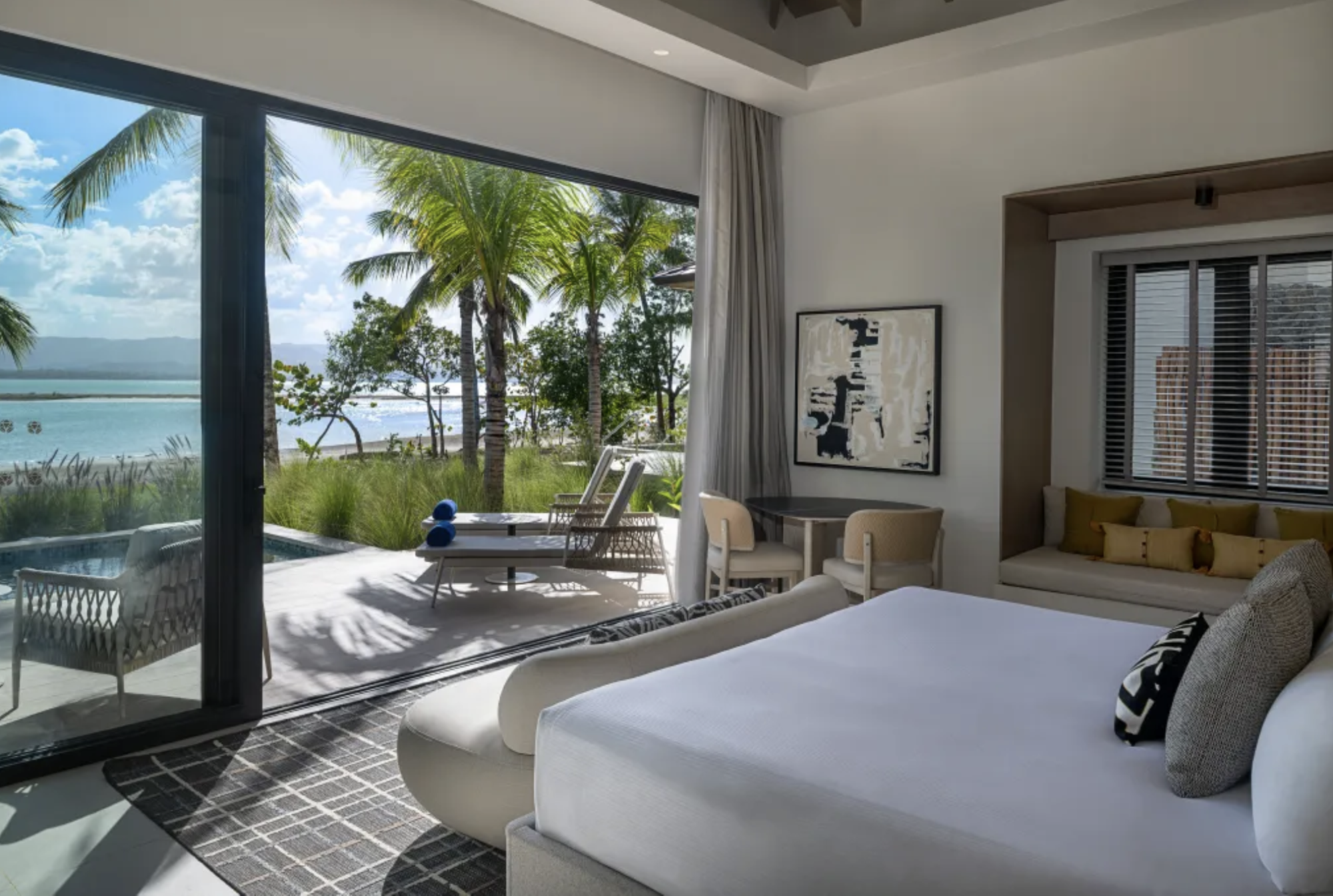 Oceanfront bungalow bedroom with palm-lined view