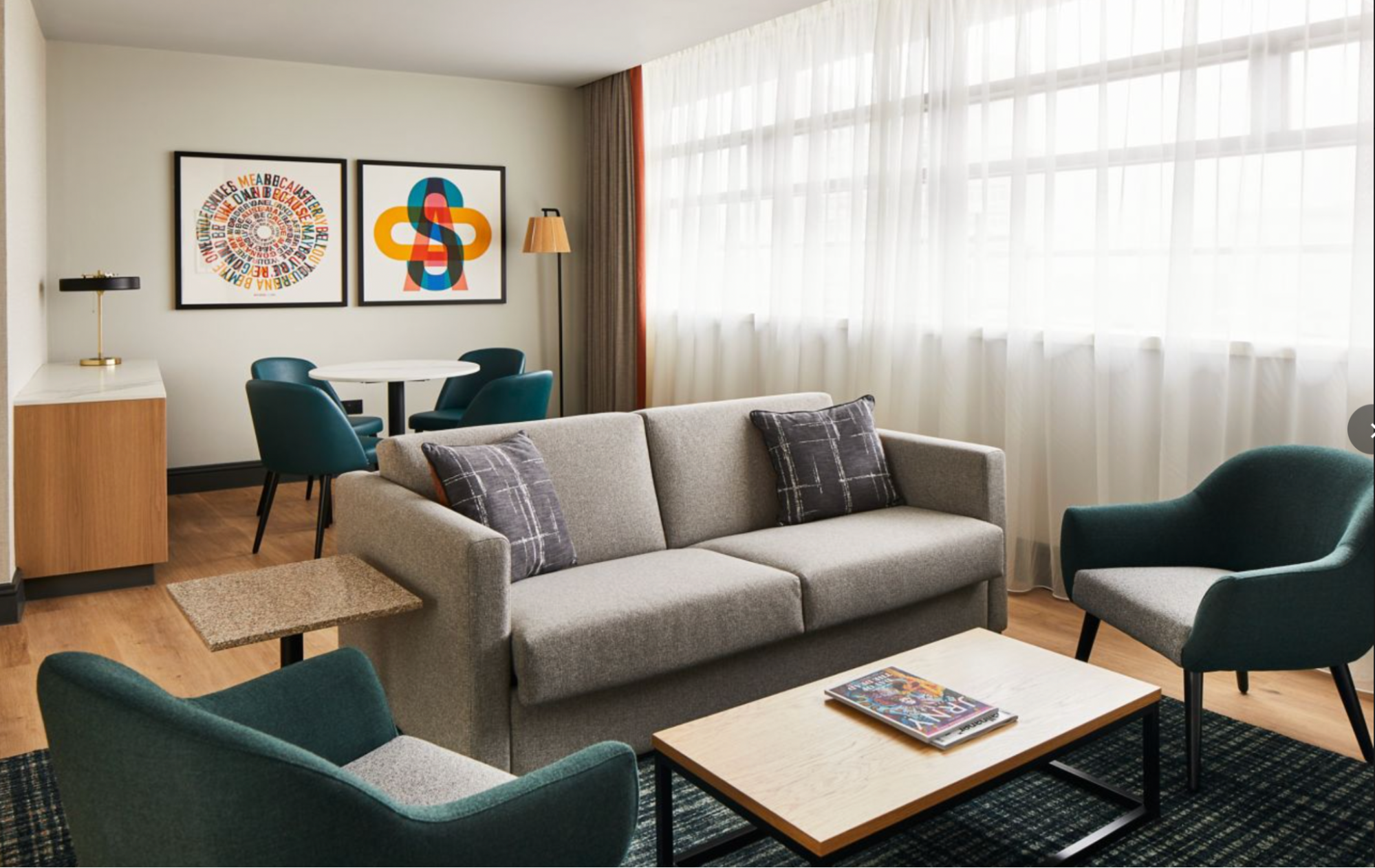 Spacious Manchester hotel suite with sofa and large windows