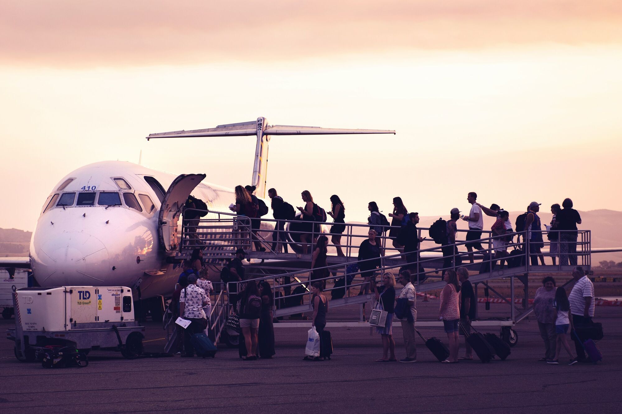 Passengers boarding an aircraft at sunset