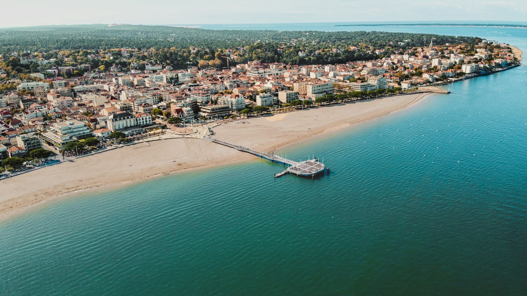Aerial view of a sandy beach and coastal town near Bordeaux