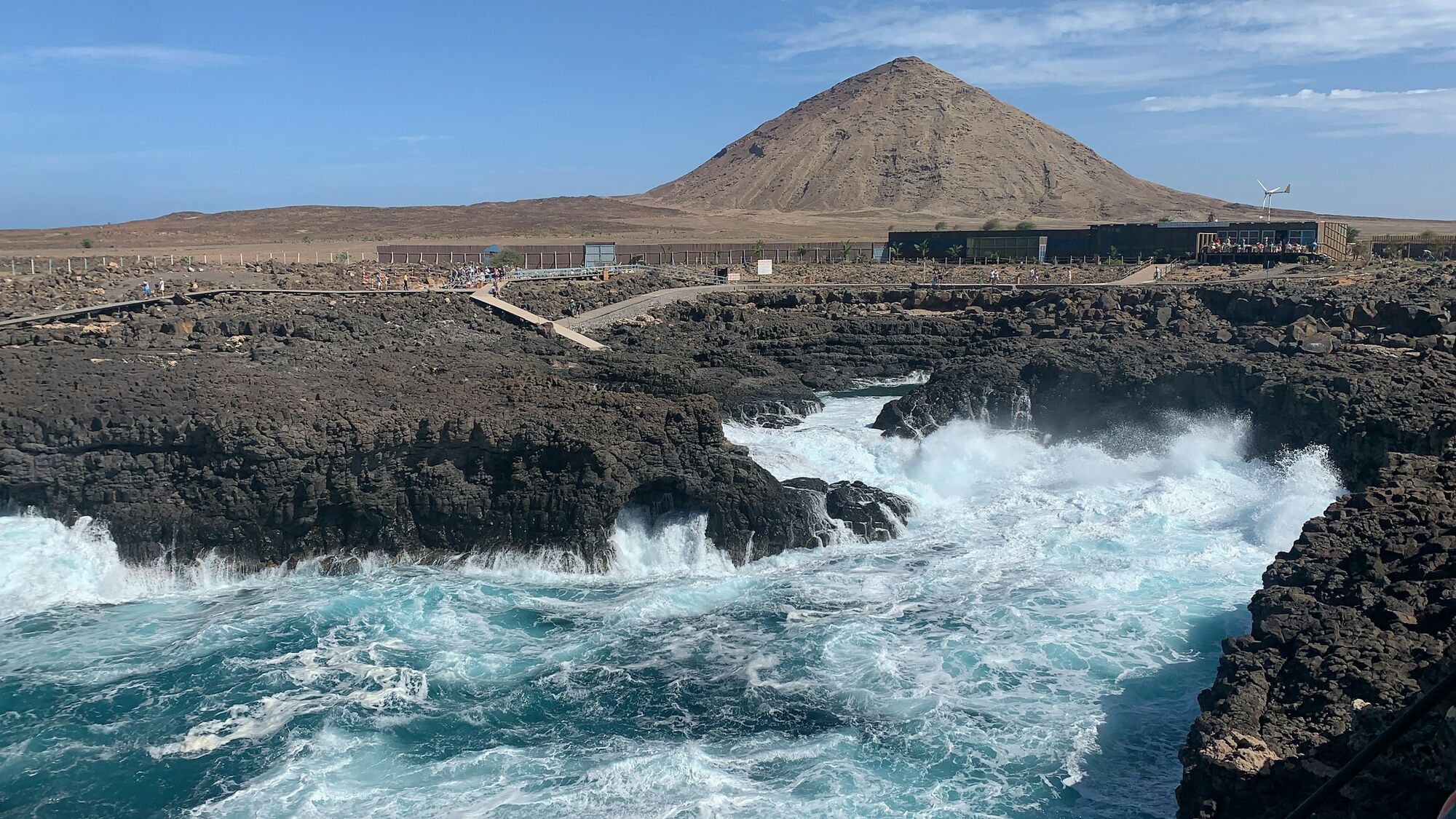 Rocky Cape Verde coastline with waves and a volcanic hill