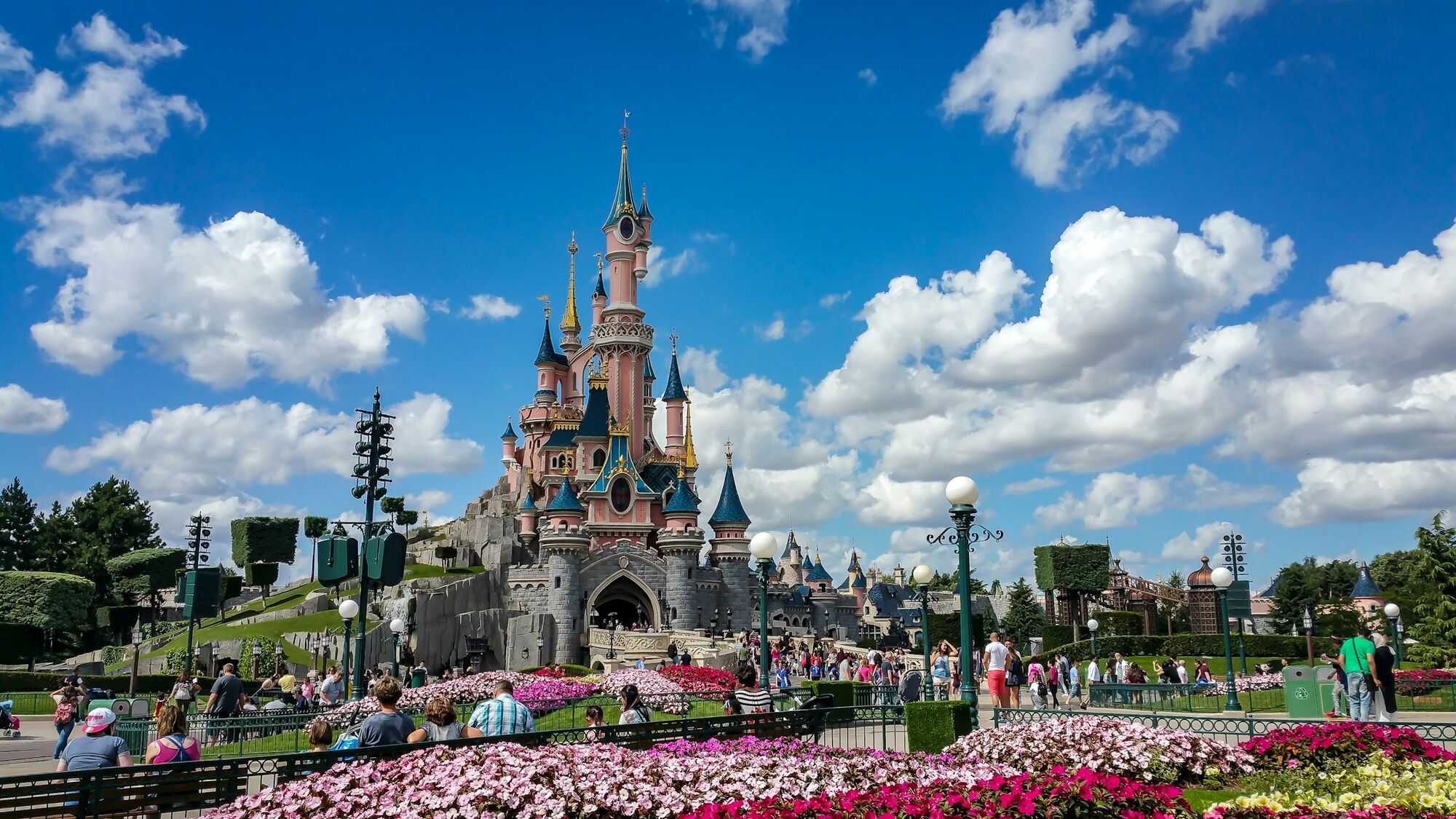 Disneyland Paris castle with visitors under a blue sky
