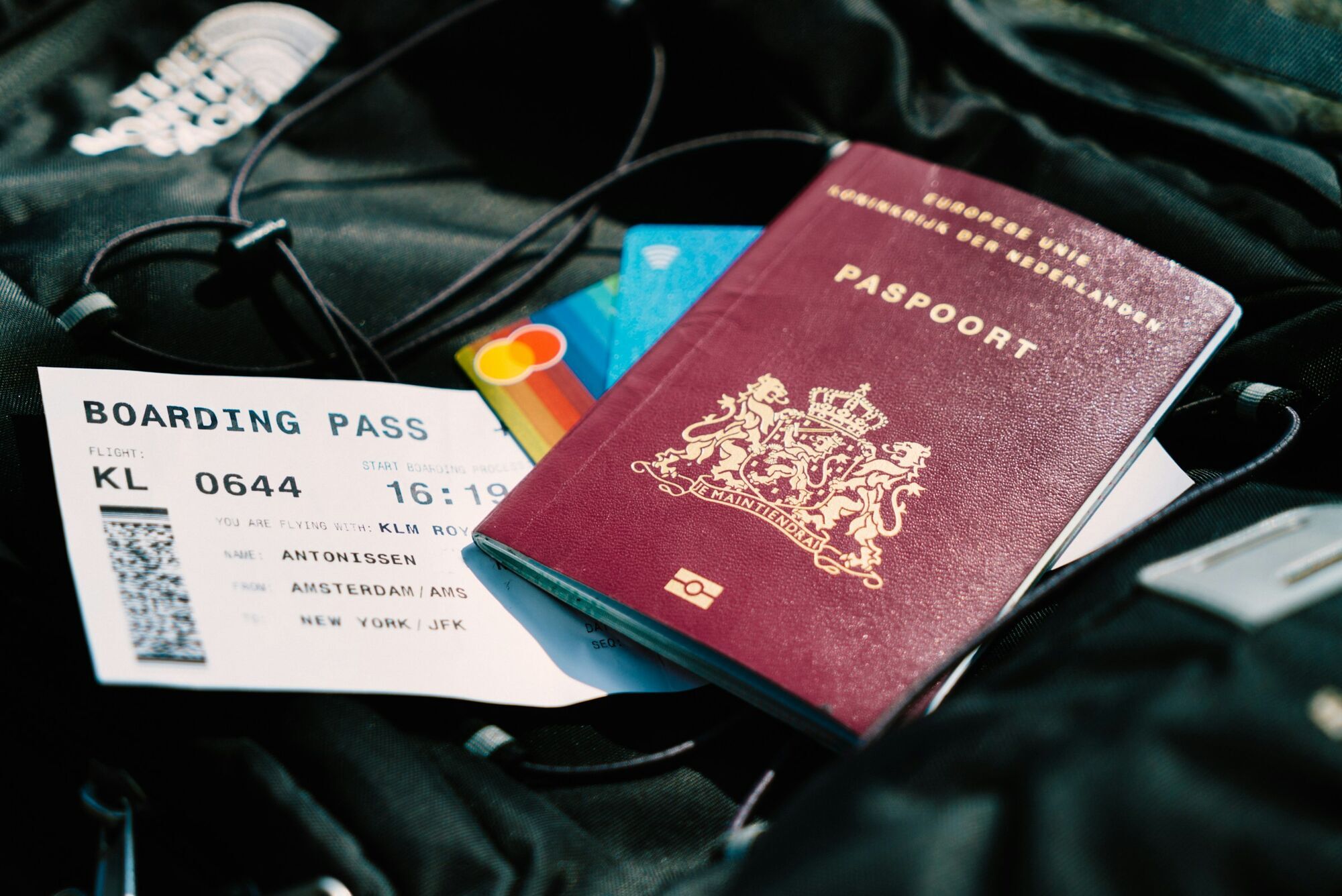 Dutch passport and boarding pass placed on a travel bag