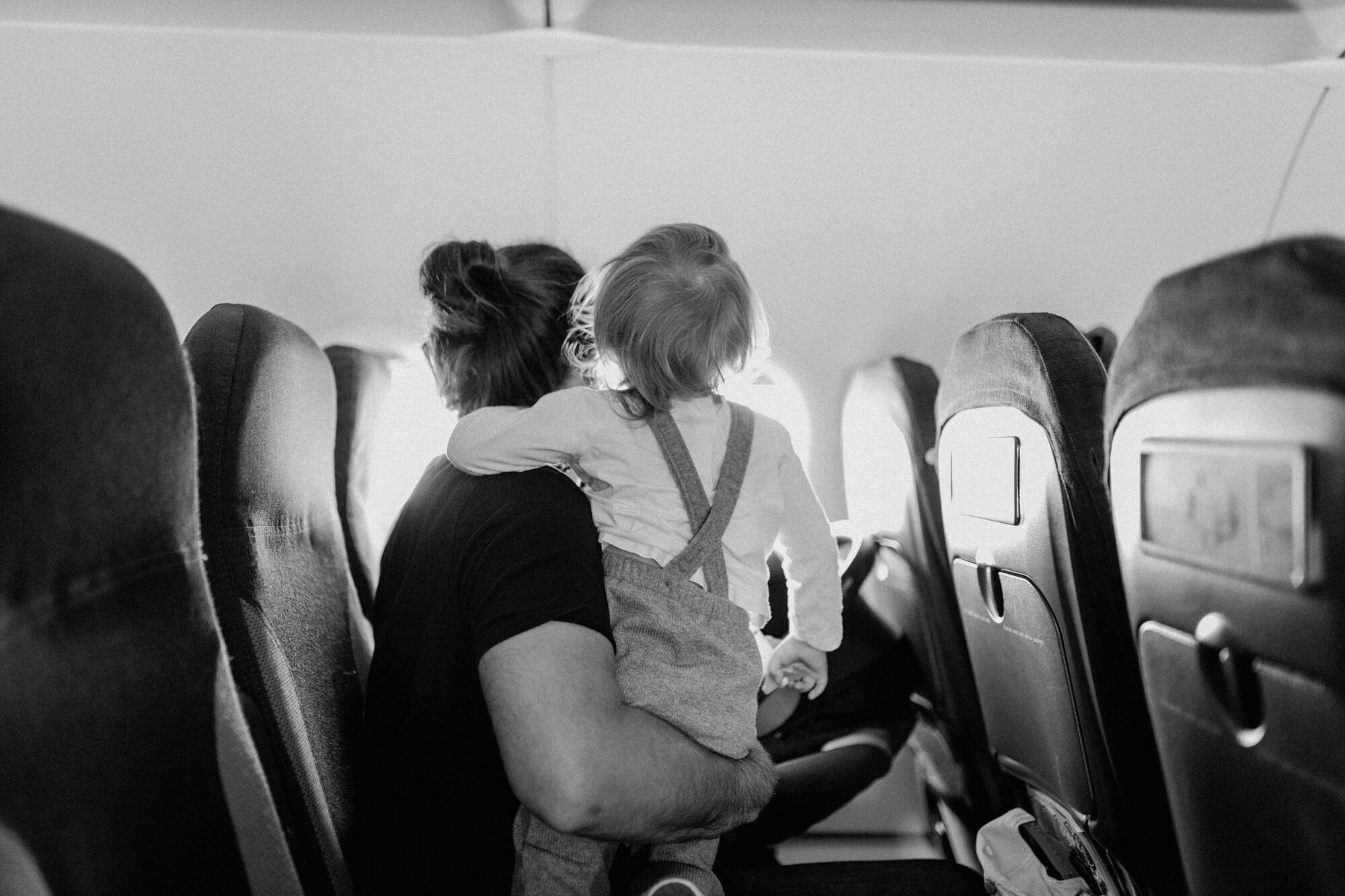 Parent holding a young child inside an aircraft cabin