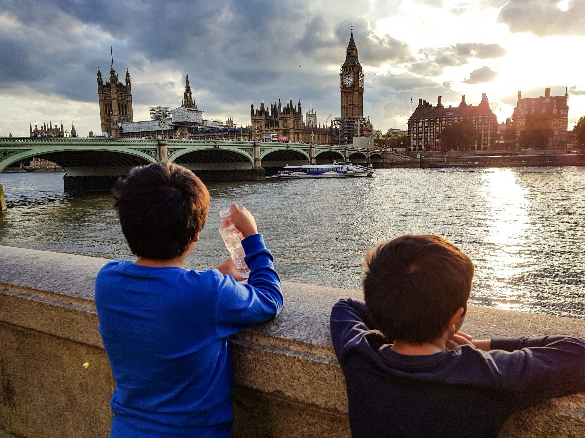 Visitors overlooking the River Thames in warm weather