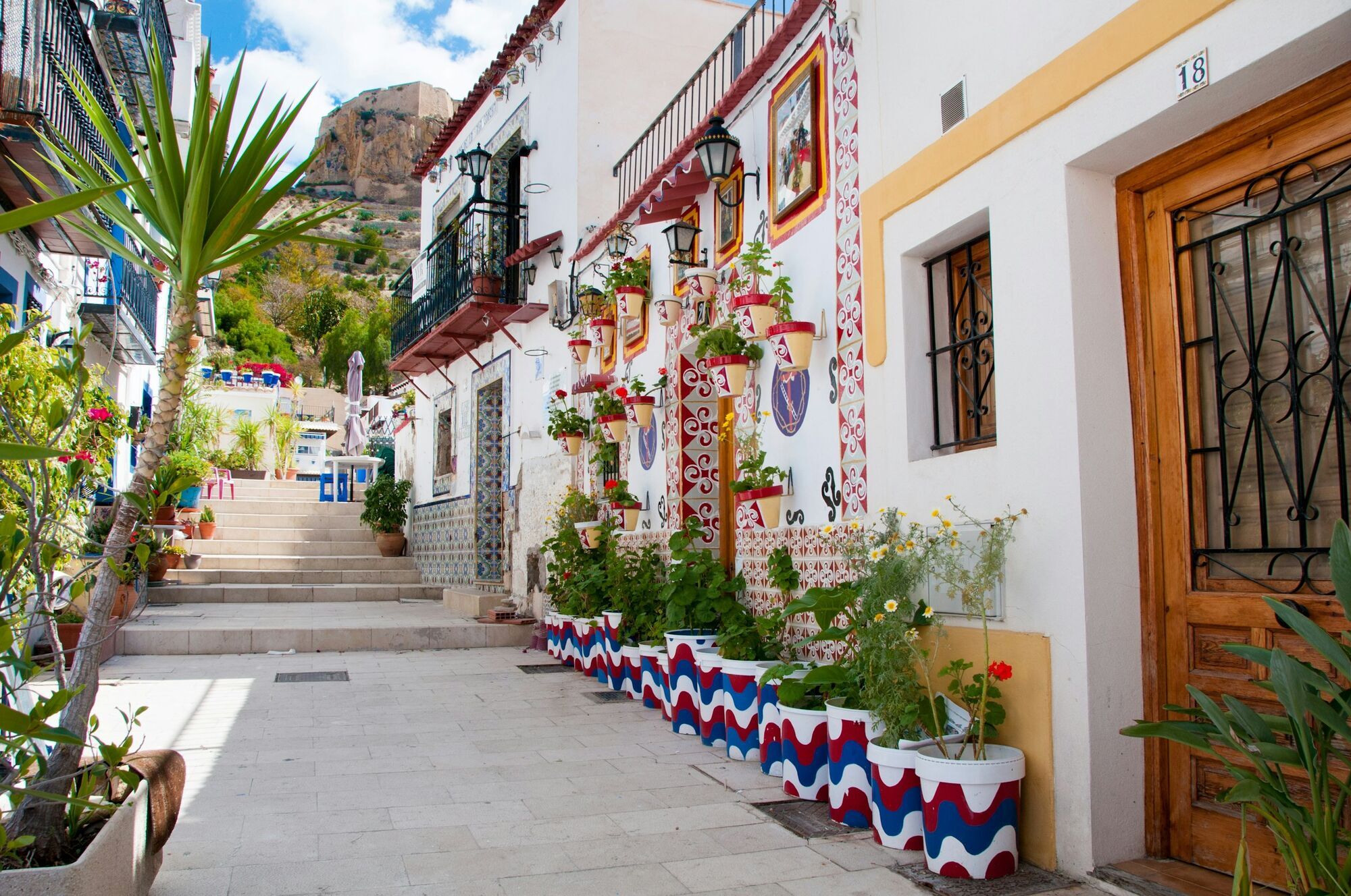 Colourful street in Alicante with white houses and potted plants