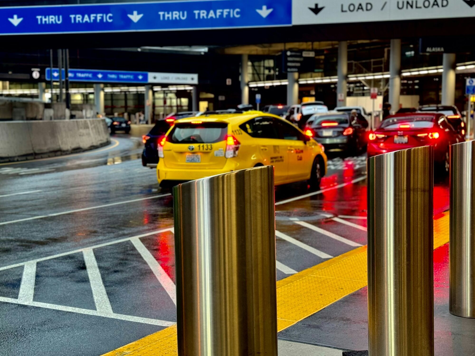 Taxi and cars waiting near an airport load and unload area
