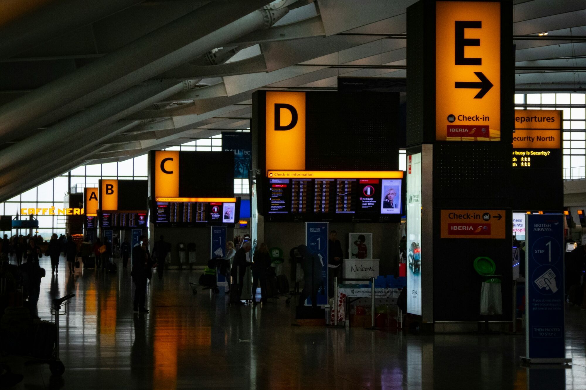 Airport check-in area with departure signs and passengers