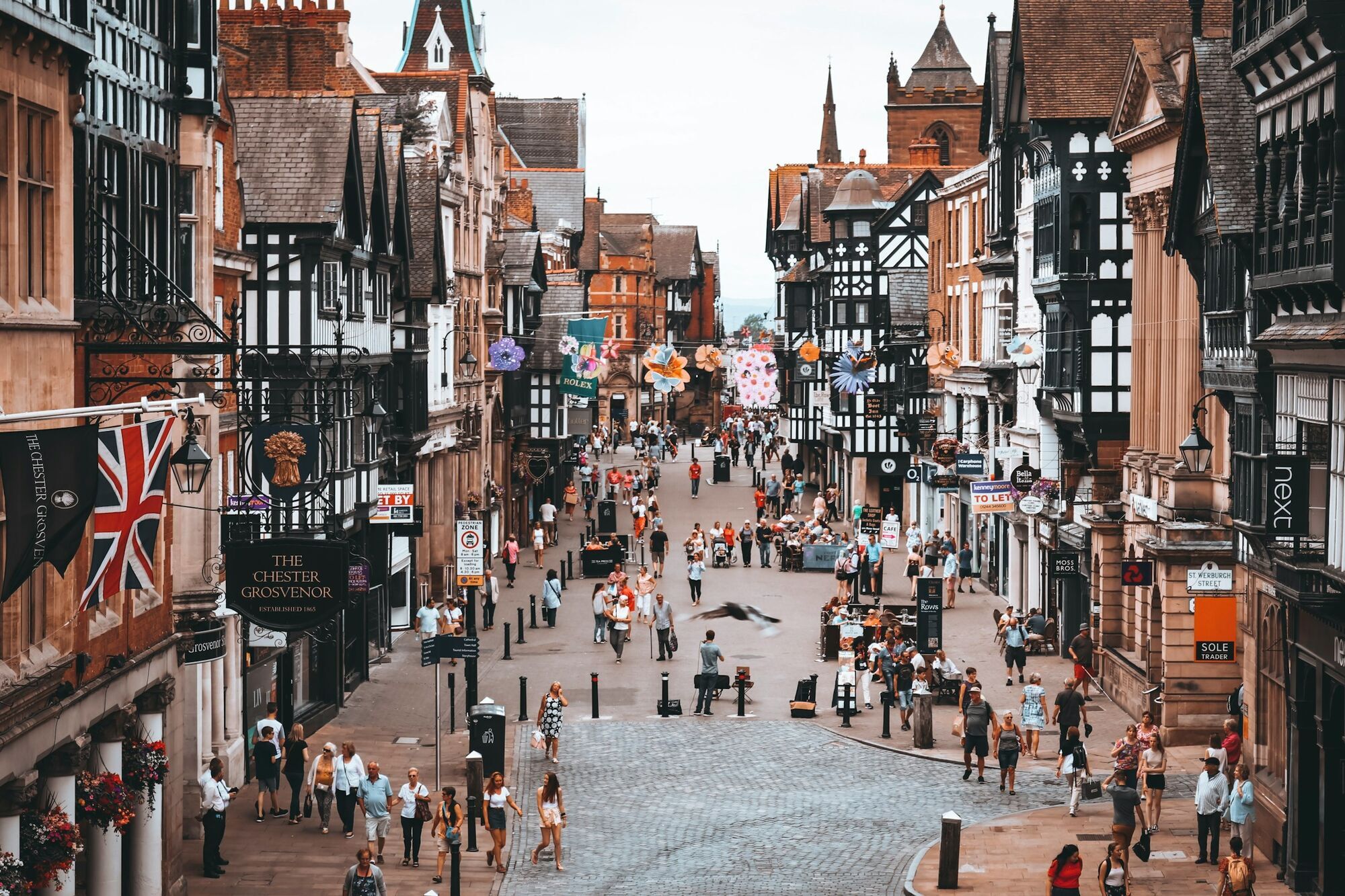 Busy historic shopping street in Chester with Tudor-style buildings