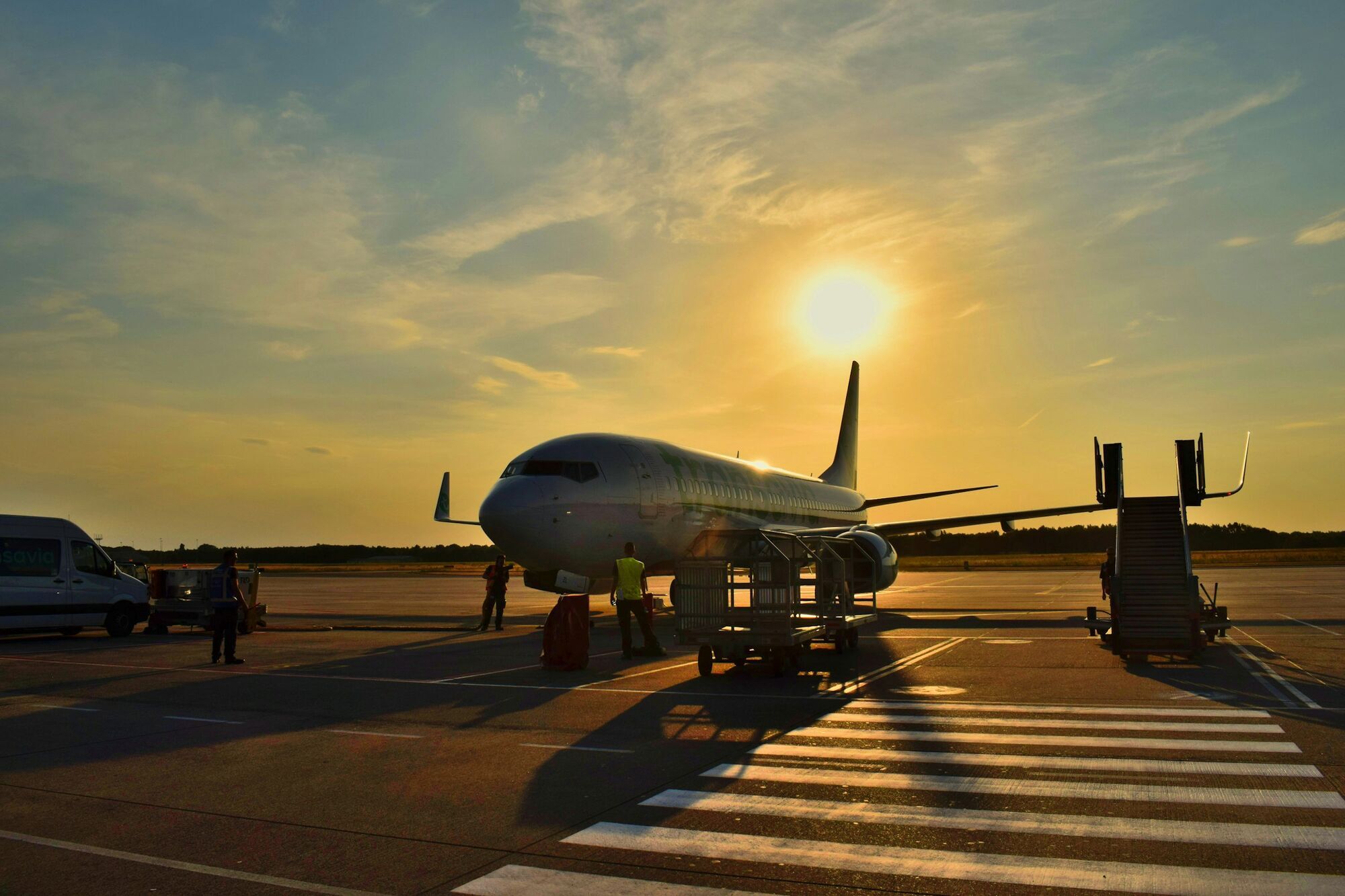 Transavia aircraft parked on the tarmac at sunset