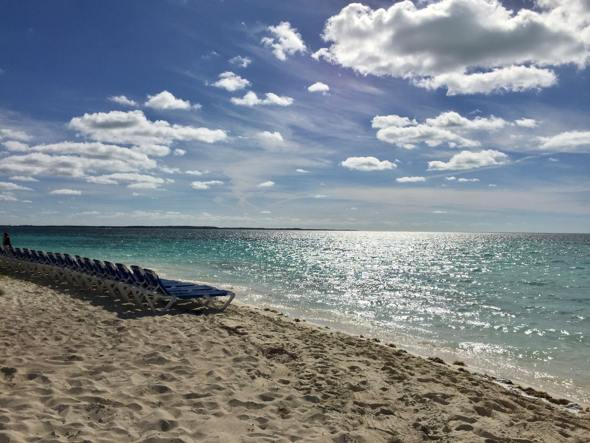 Sandy beach with sun loungers and clear Mediterranean-style waters