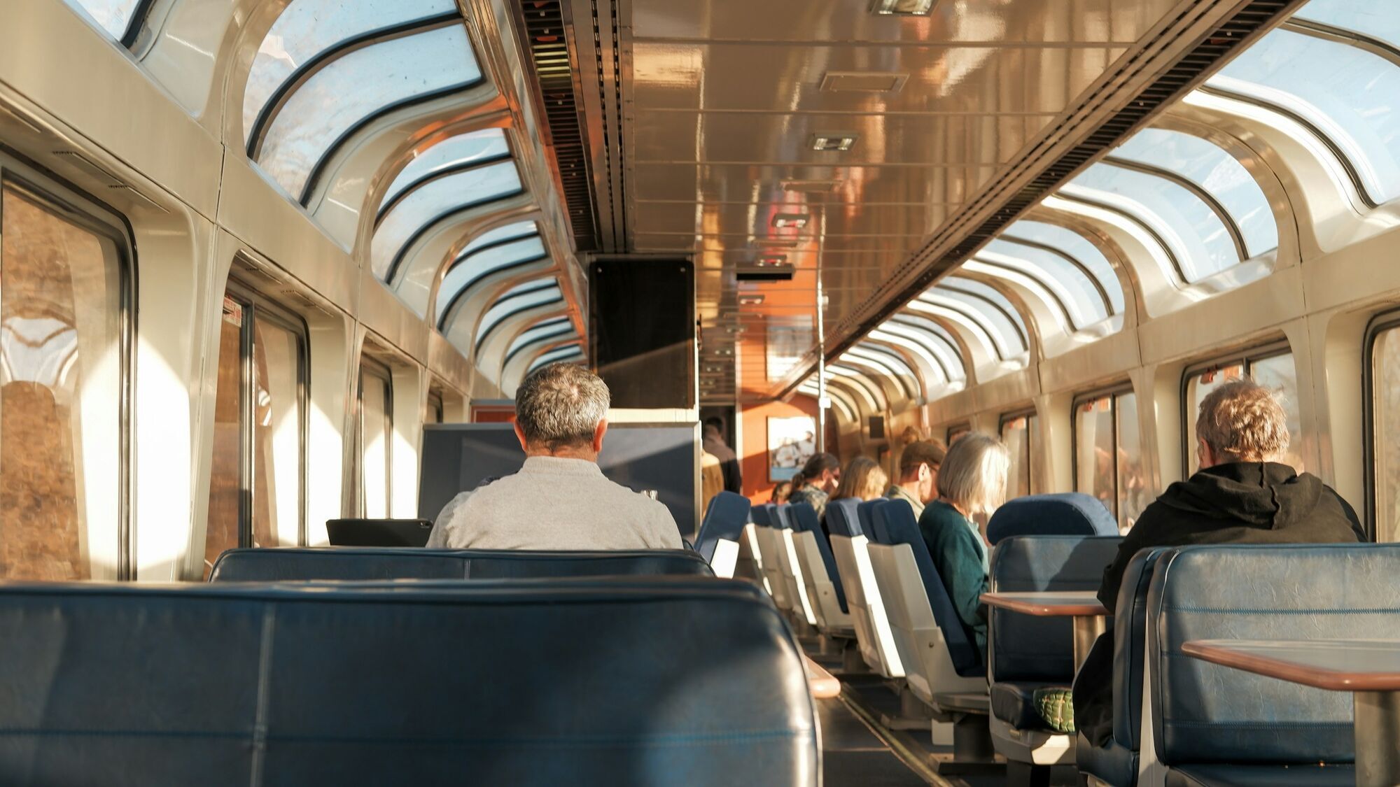 Passengers seated inside a panoramic train carriage