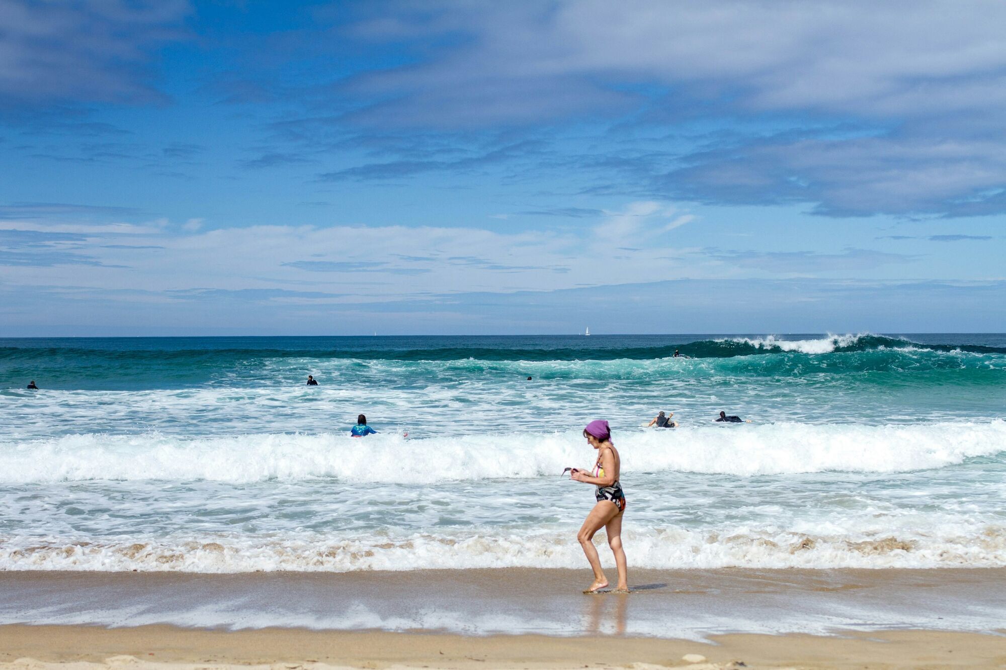 Swimmers and surfers at a sandy beach