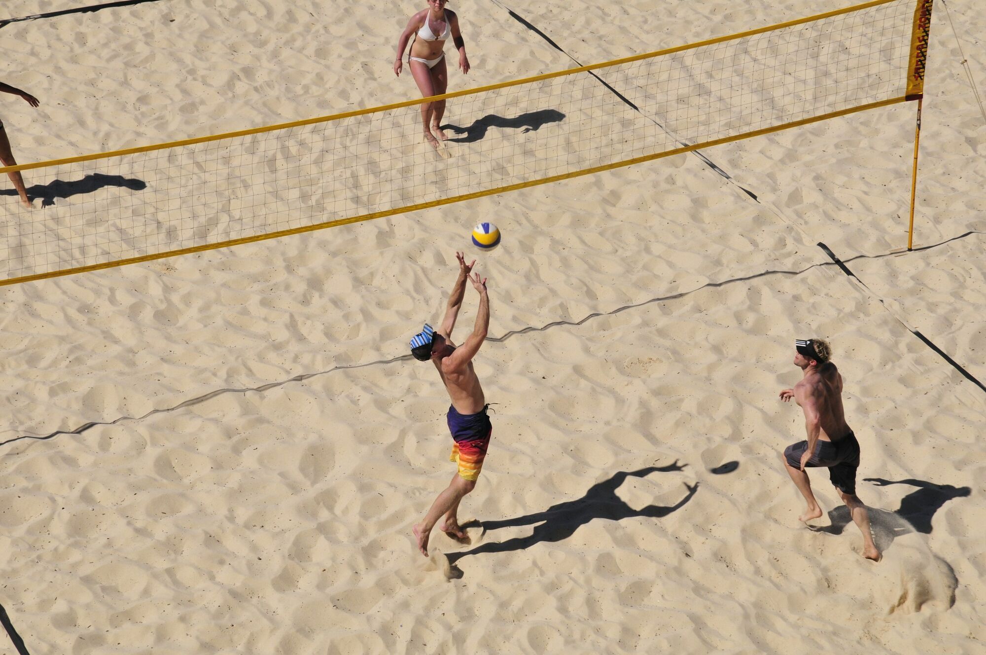 Beach volleyball game on a marked sand court