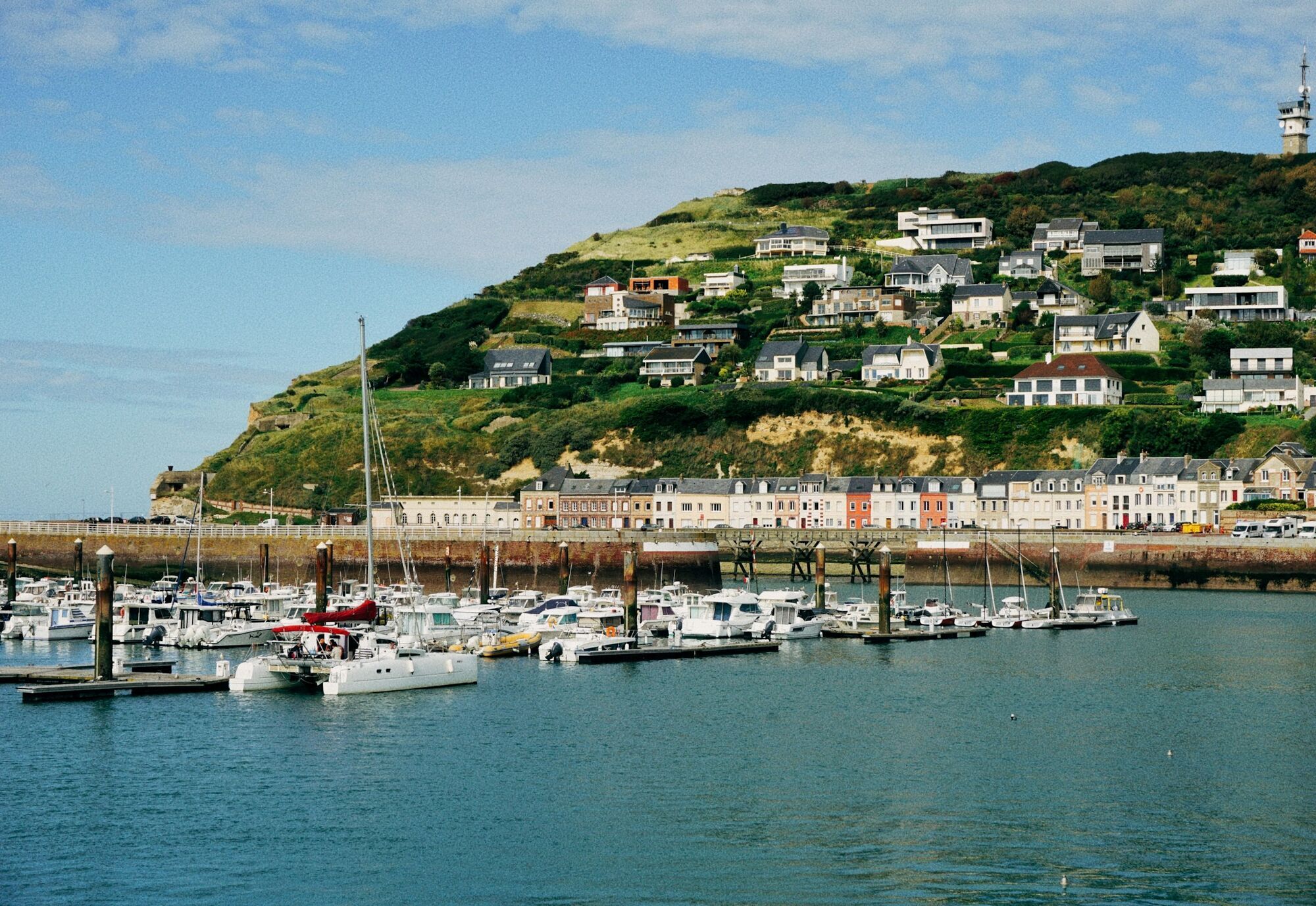 Boats in Fécamp marina below hillside homes