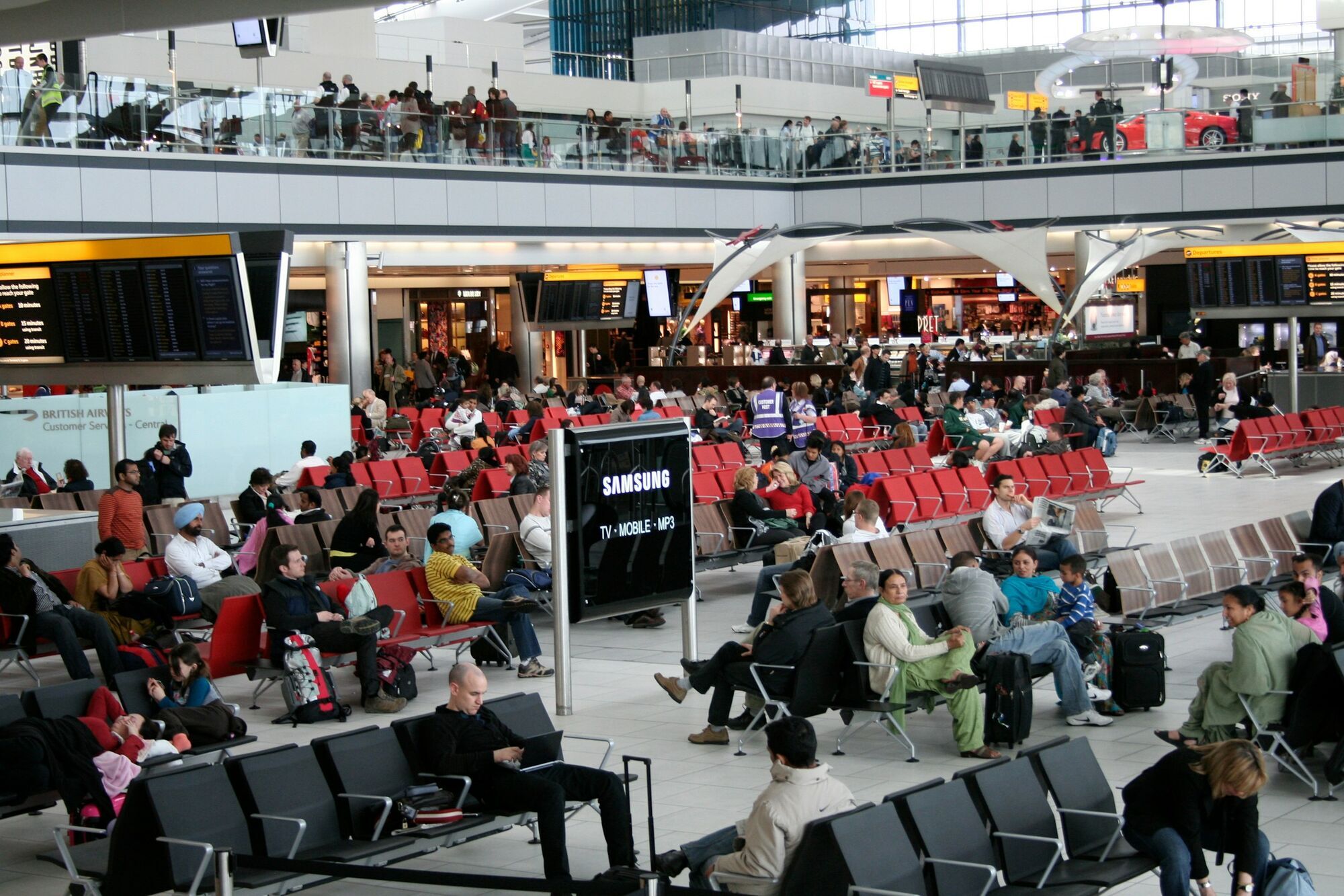 Passengers waiting inside a Heathrow departure lounge