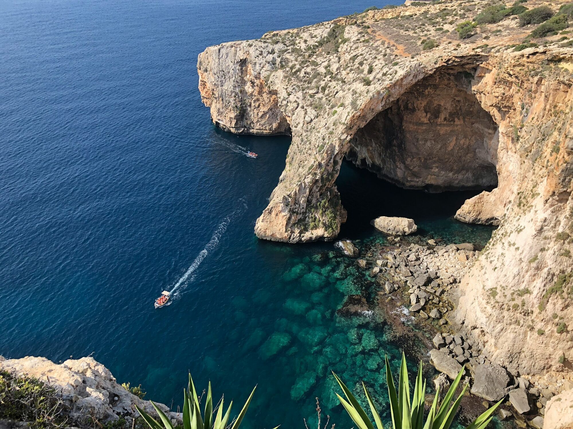 Boat passing beneath Malta’s Blue Grotto sea arch