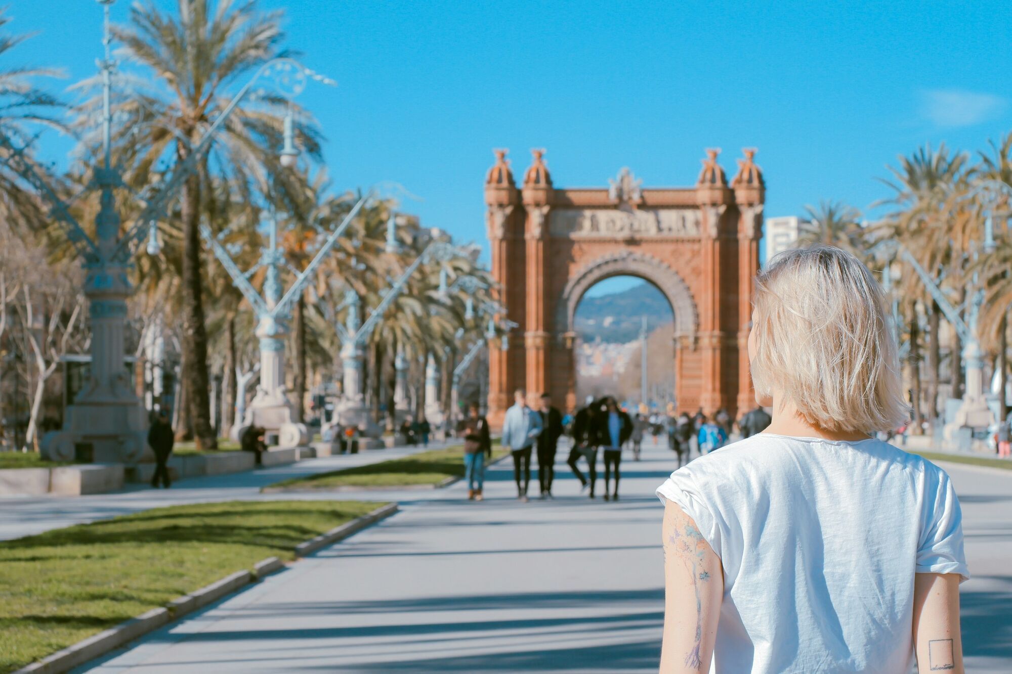 Tourist walking towards Barcelona’s Arc de Triomf