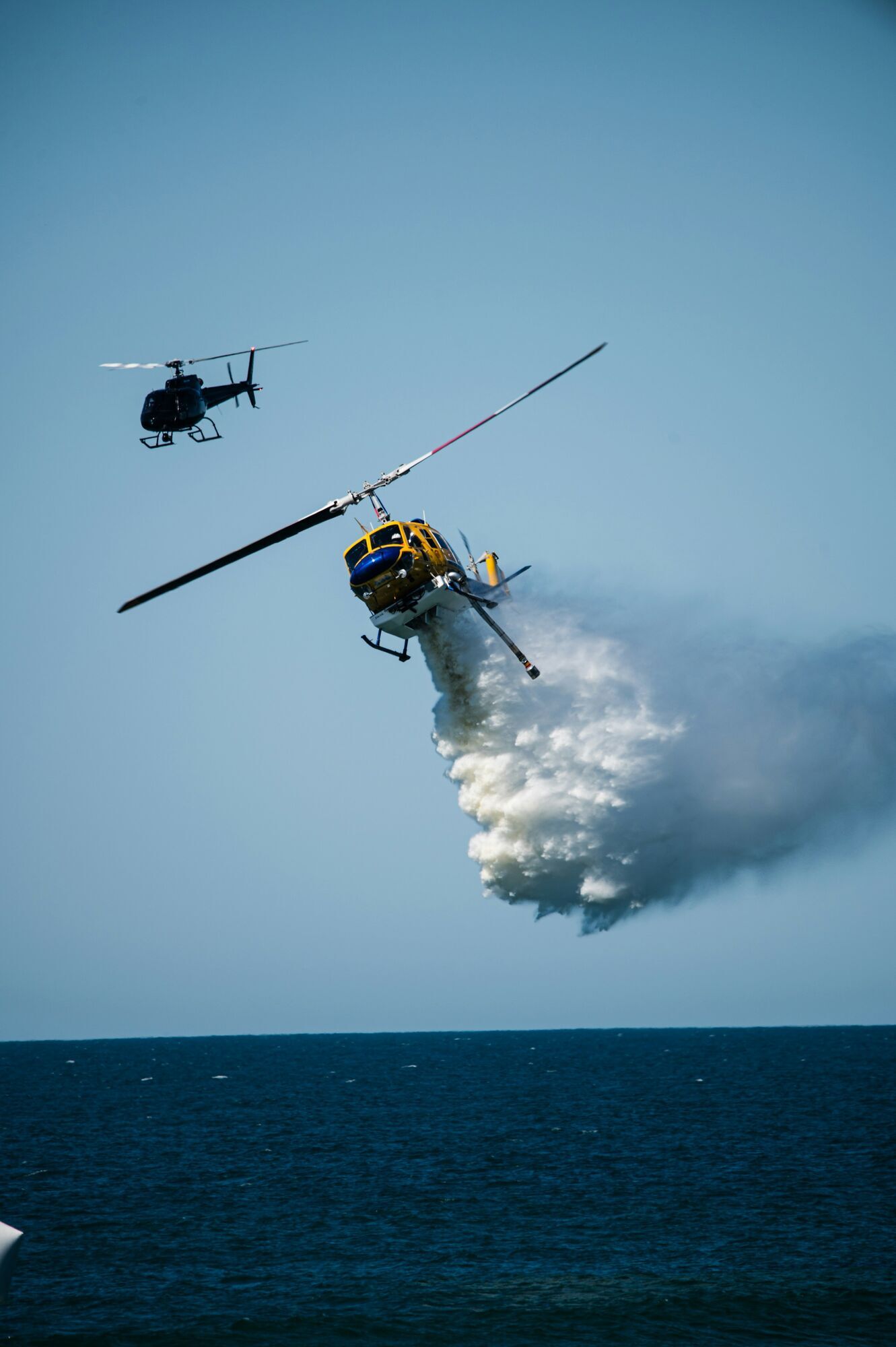 Firefighting helicopter dropping water over the sea