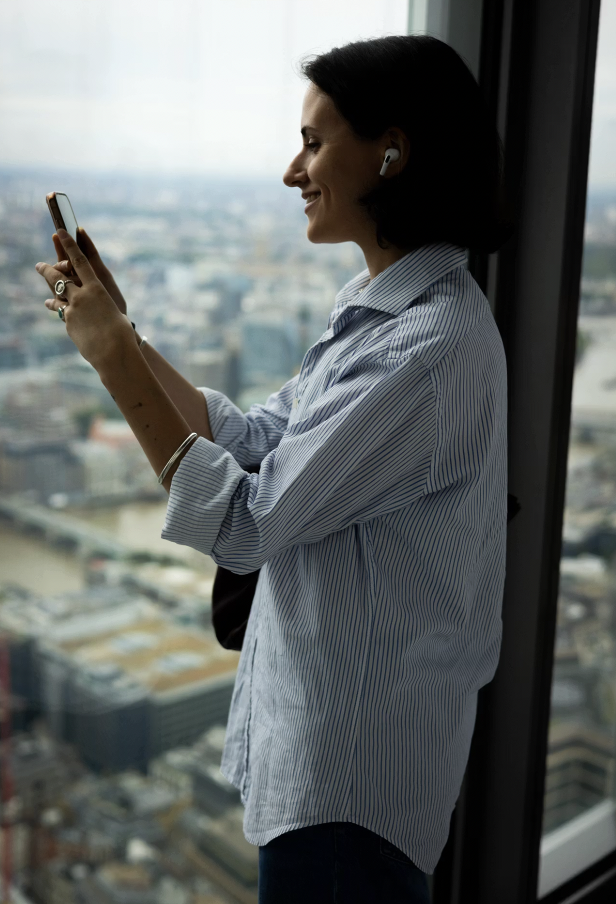 Visitor photographing London from a viewing gallery
