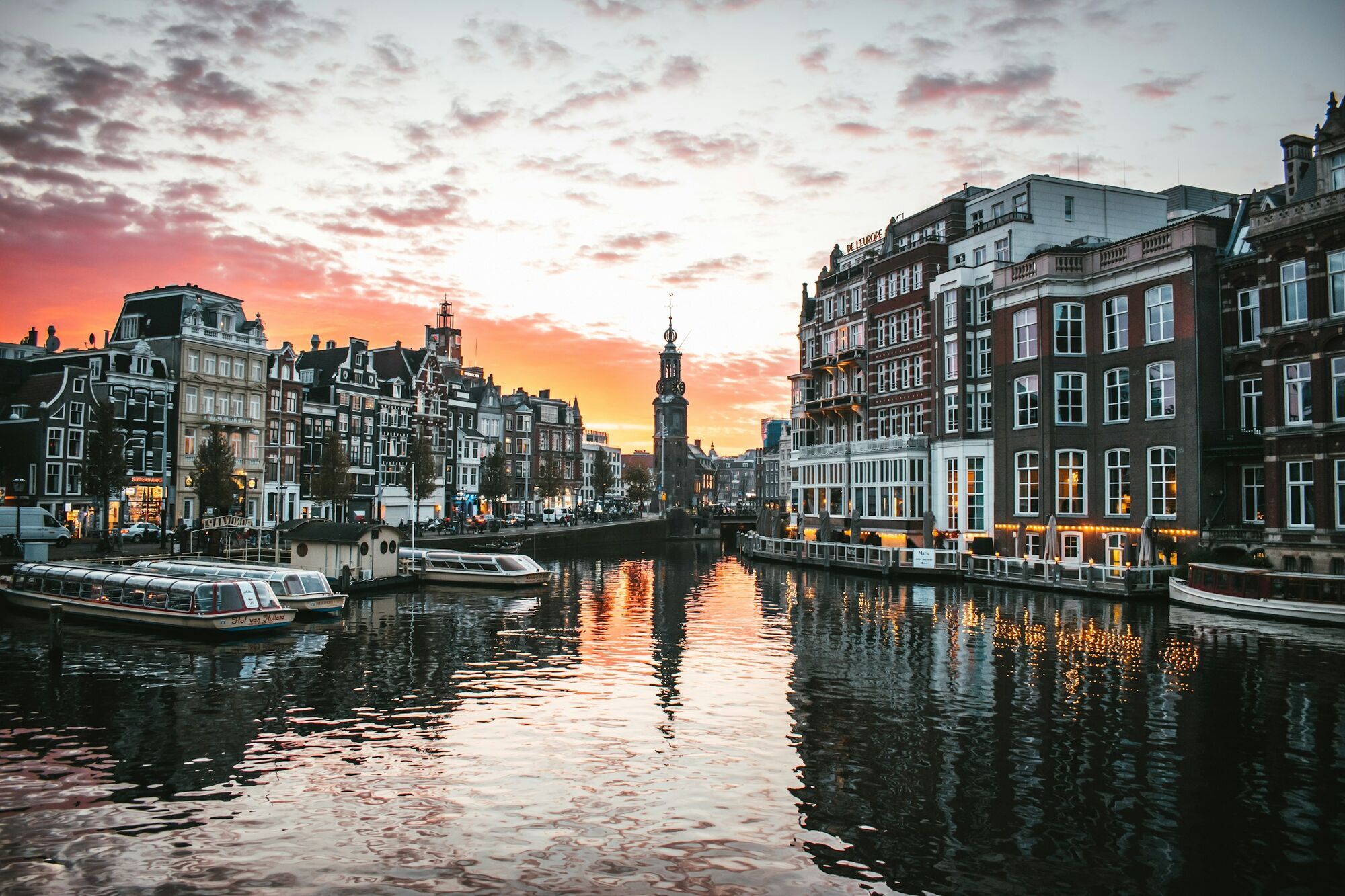Amsterdam canal lined with historic buildings at sunset