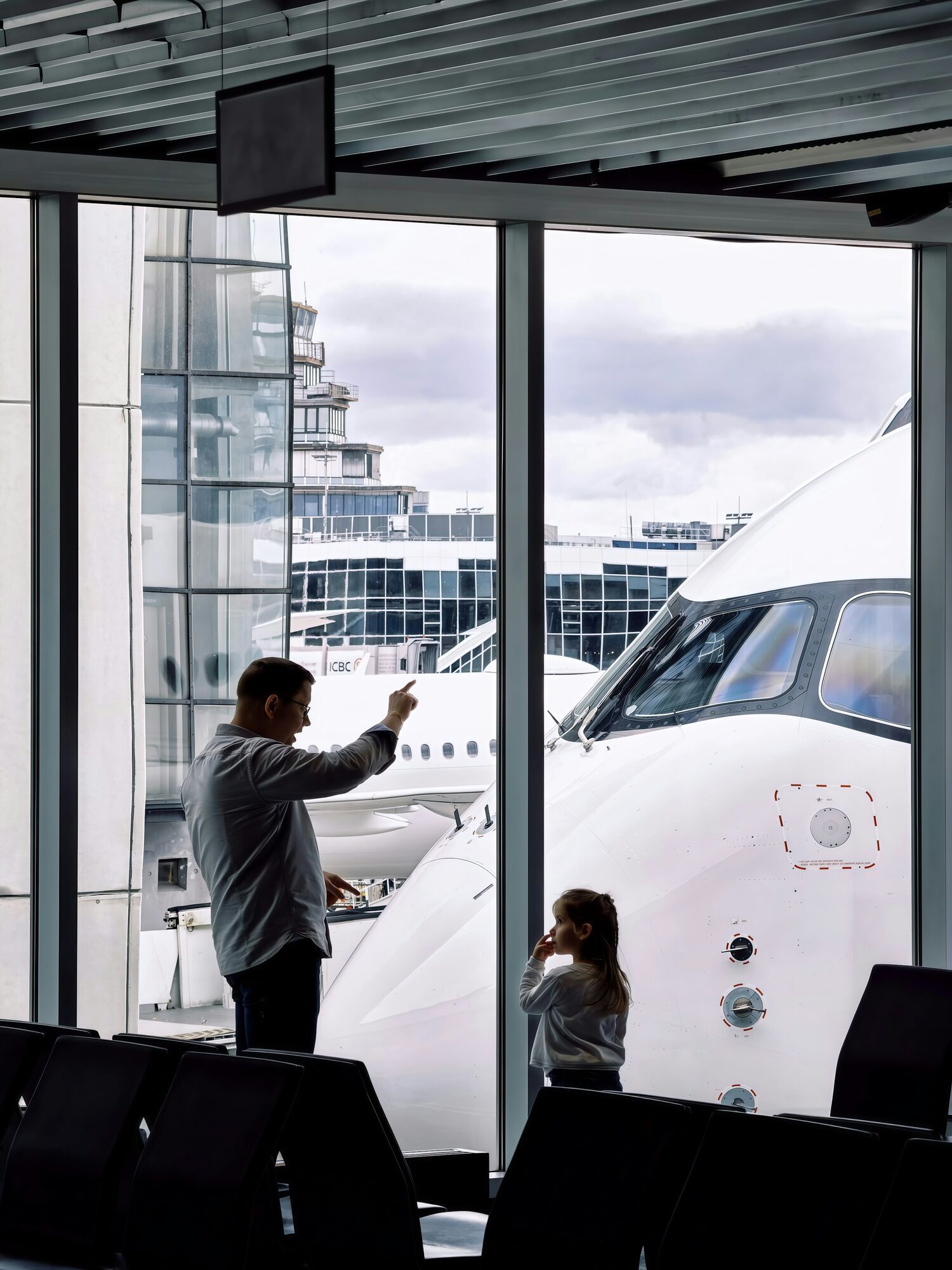 Father and child waiting at airport gate