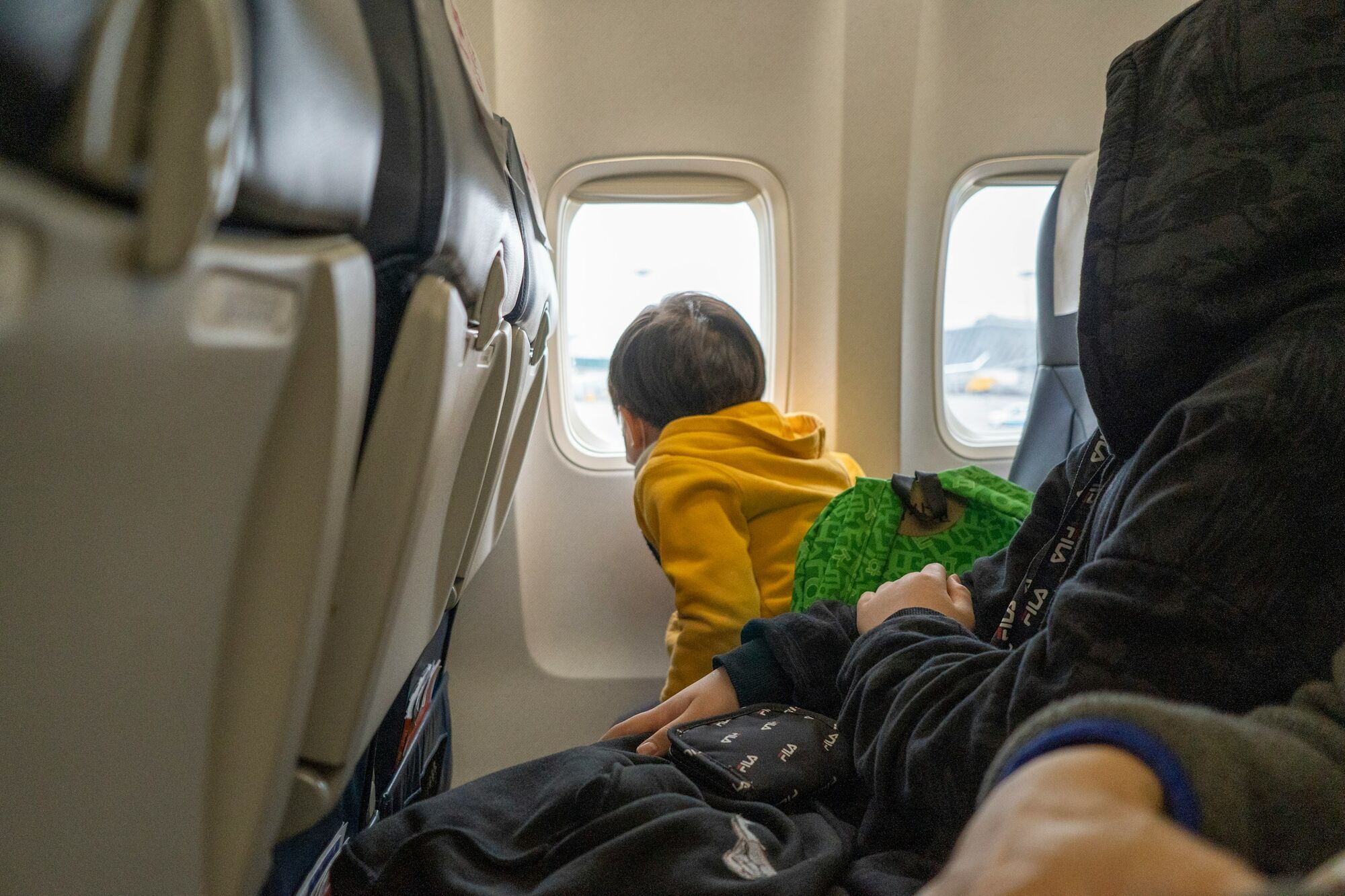 Child seated beside an aircraft window