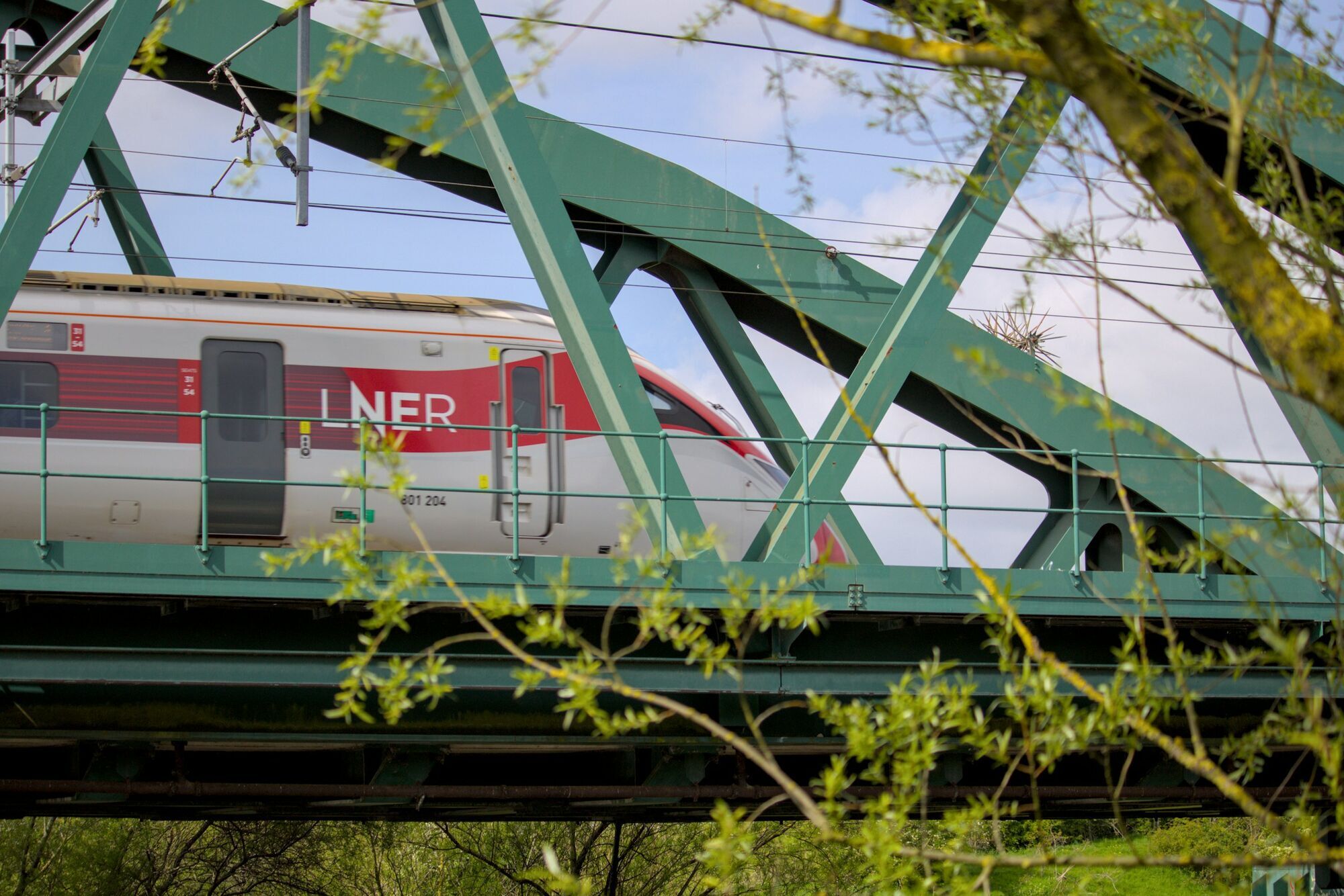 LNER train travelling across a railway bridge