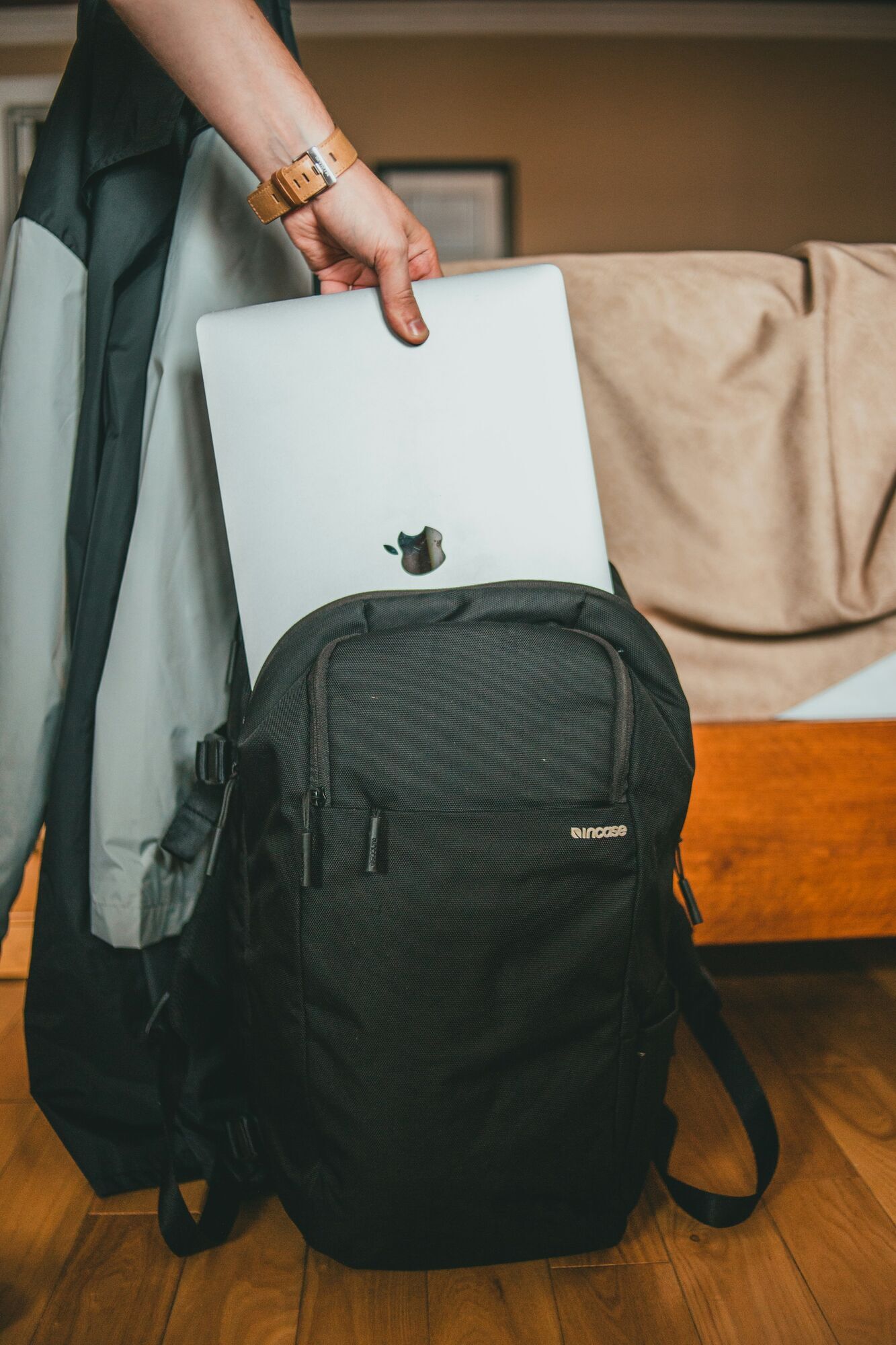 Traveller packing laptop into backpack