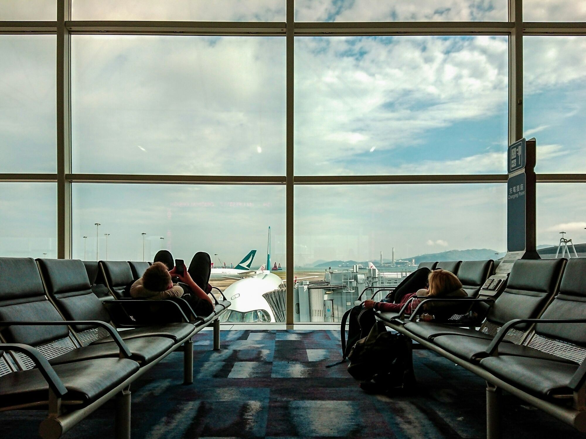 Travellers waiting at an airport gate