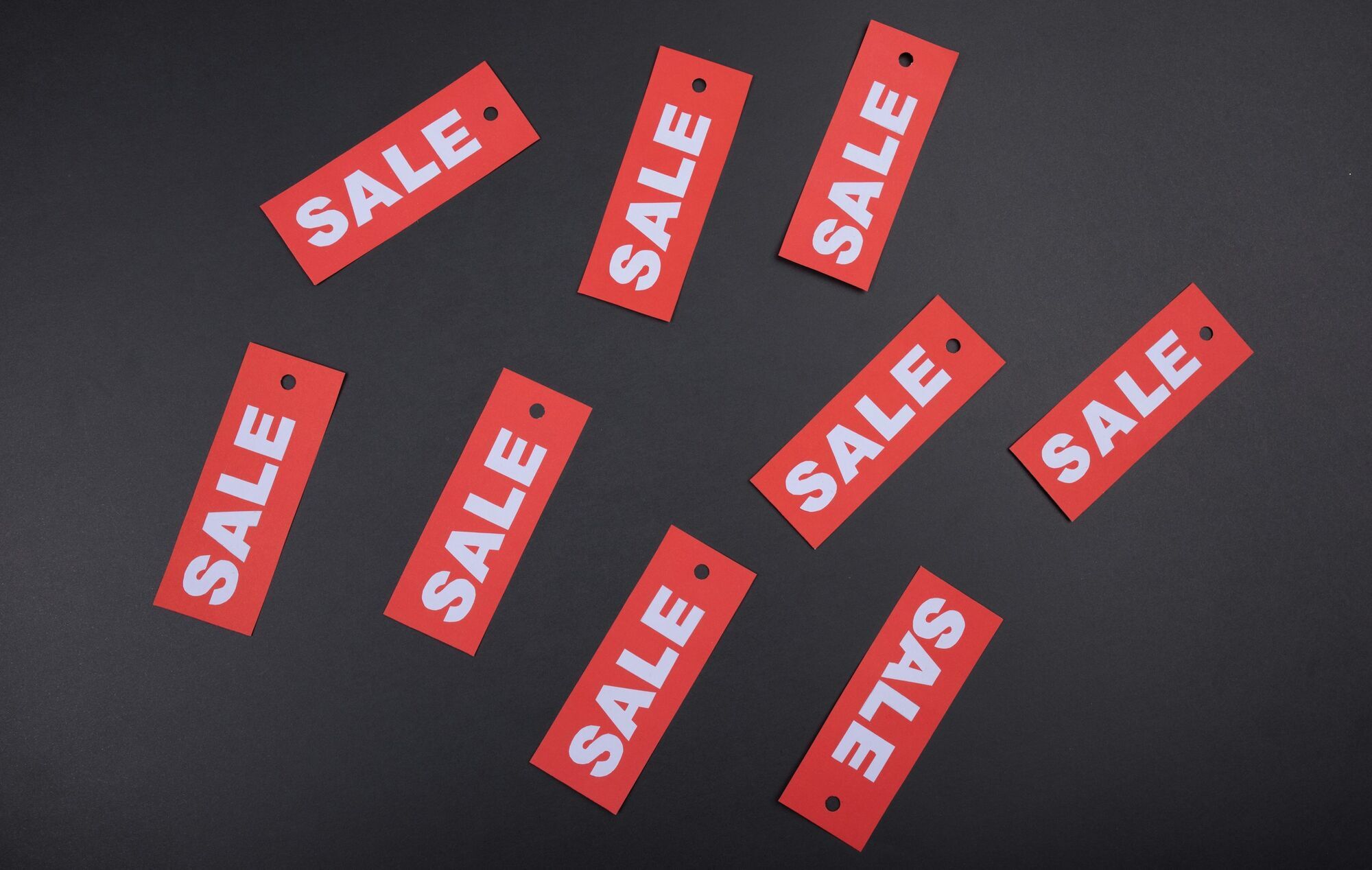 Red sale tags on a dark background