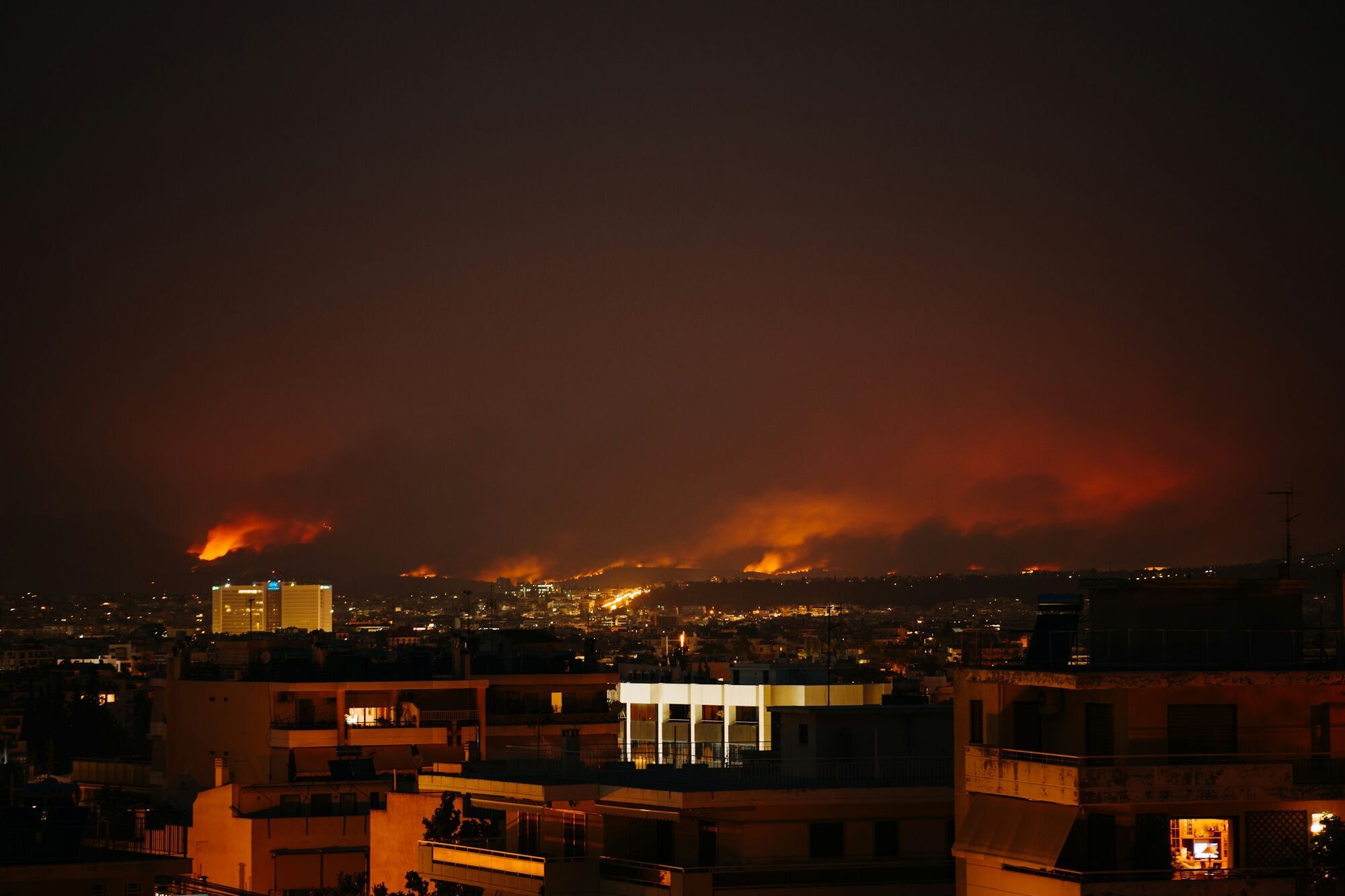 Wildfire burning near a city at night