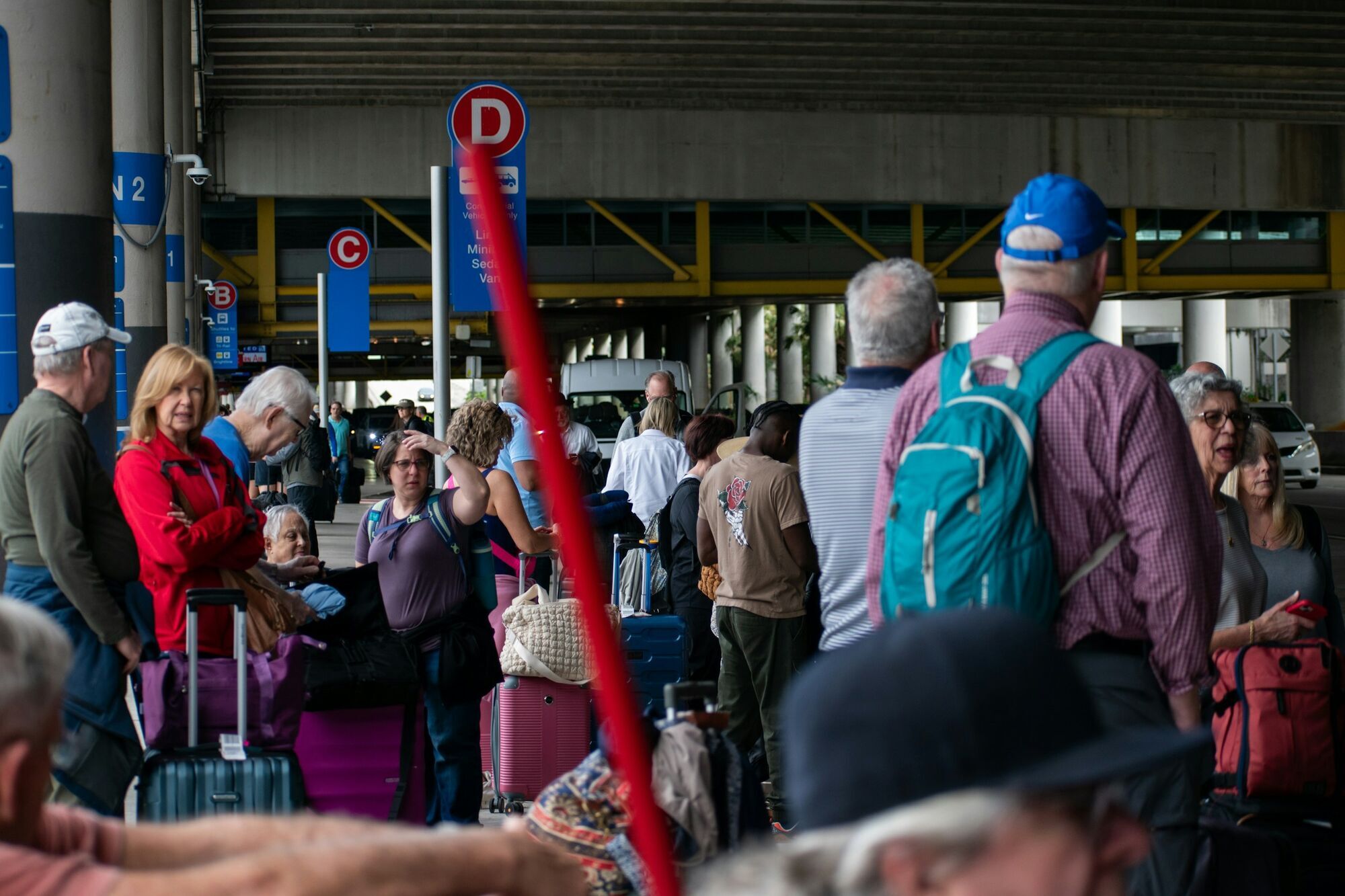 Travellers waiting outside an airport terminal