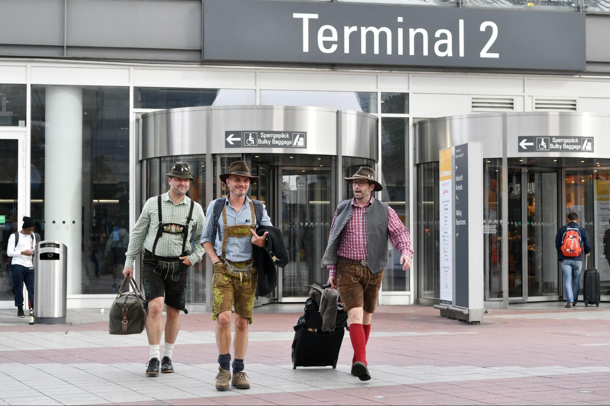 Travellers in traditional Bavarian clothing outside Munich Airport Terminal 2