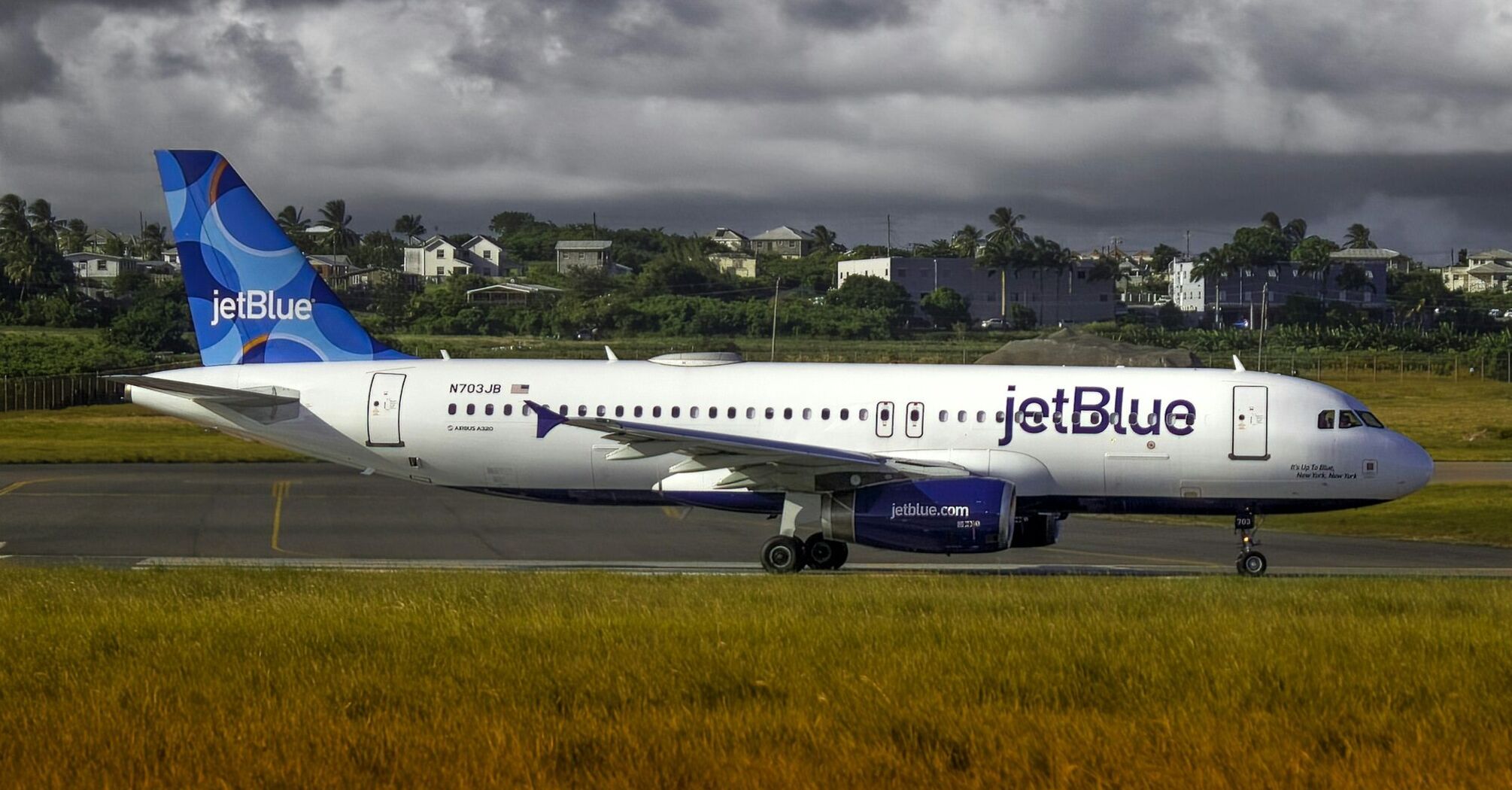 A jet blue airplane is on the runway