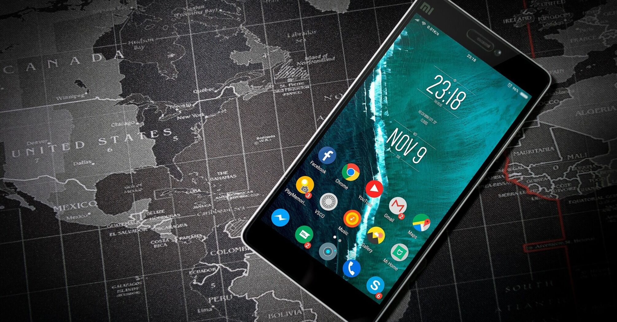 Mobile phone with applications lies on the world map 