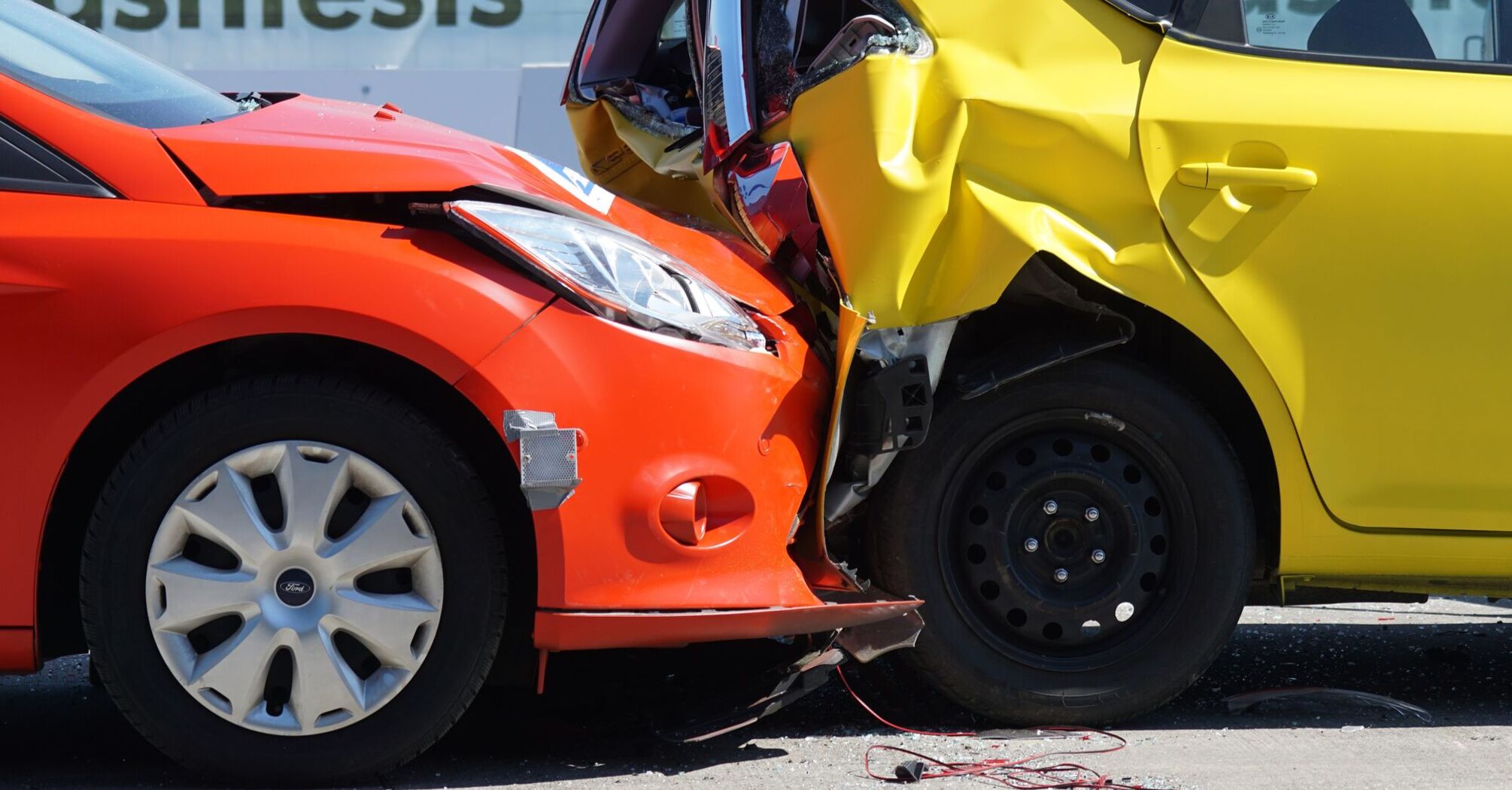Two cars, one red and one yellow, involved in a collision, depicting a typical road accident that could occur during a road trip