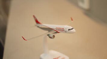 Air Arabia airplane model on a stand, placed on a table with a focus on the front part of the airplane