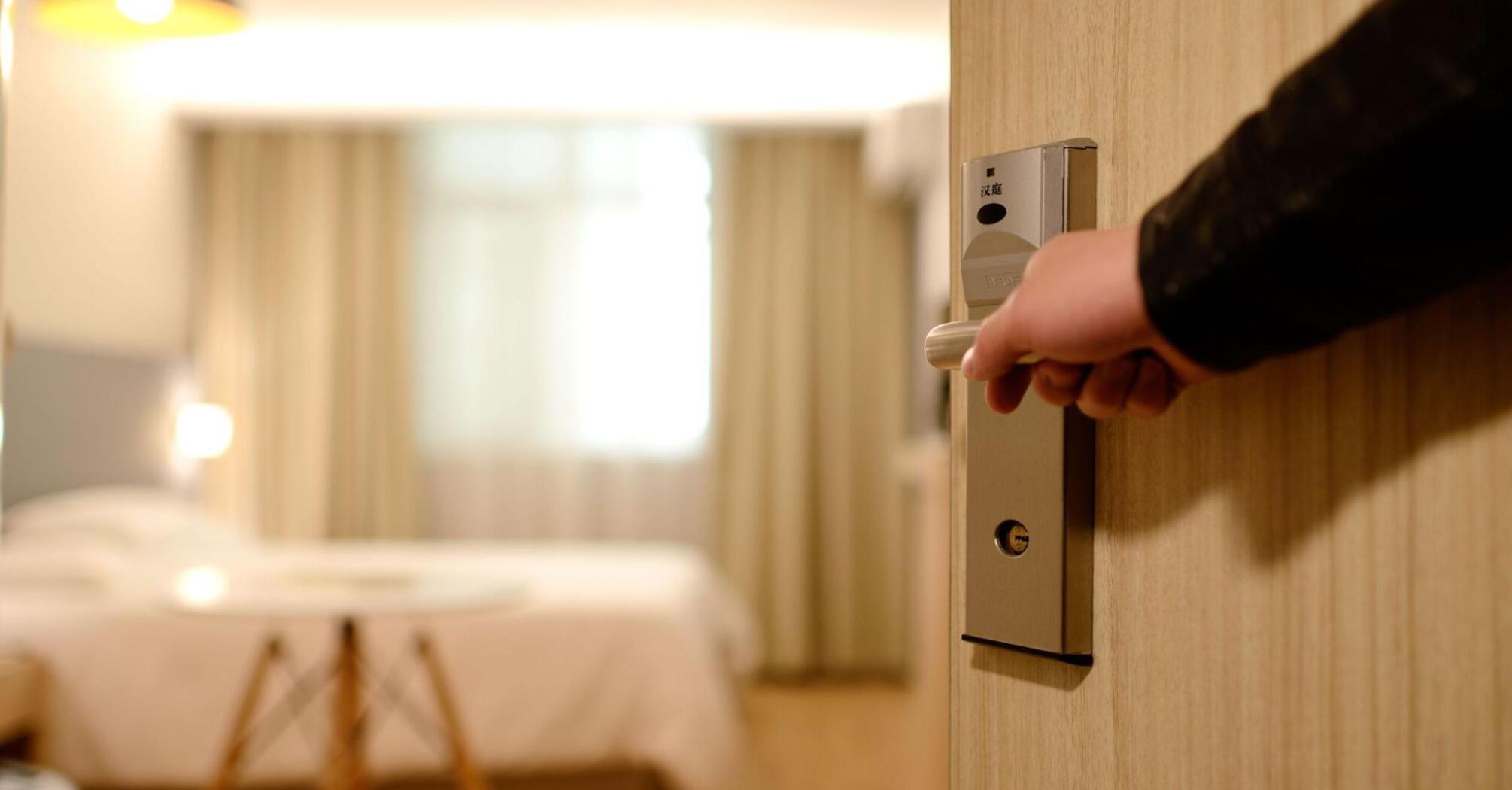 A man opens the door to his hotel room
